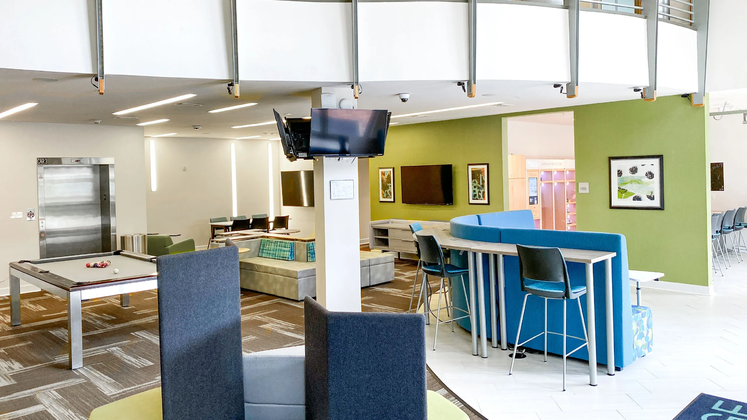 Modern communal apartment lounge with pool table, stylish seating, and vibrant decor for socializing and relaxation.