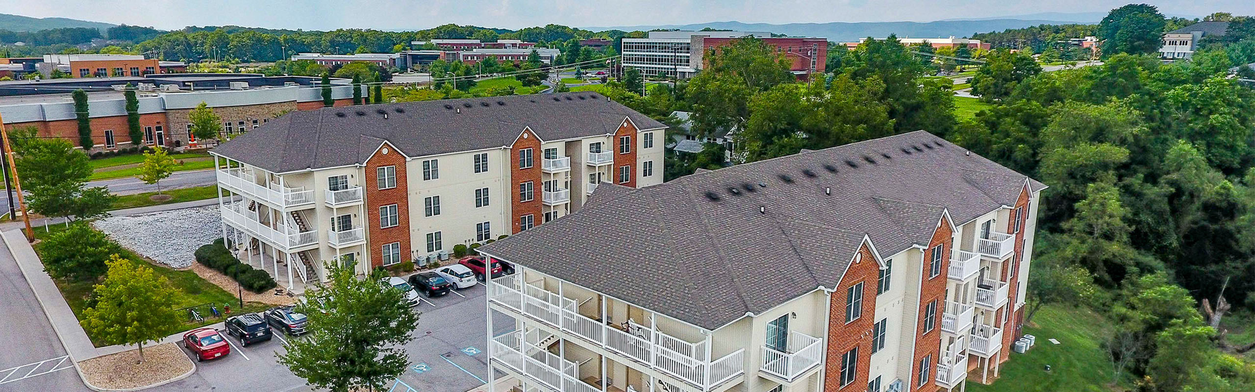 Charming apartment complex with elegant balconies and lush greenery, nestled in a vibrant community setting.