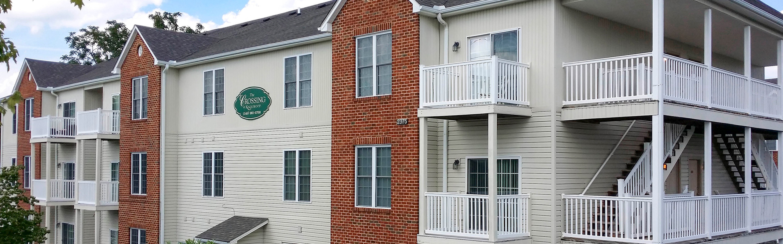 Modern apartment complex with elegant balconies and lush surroundings, offering a welcoming and stylish community living experience.
