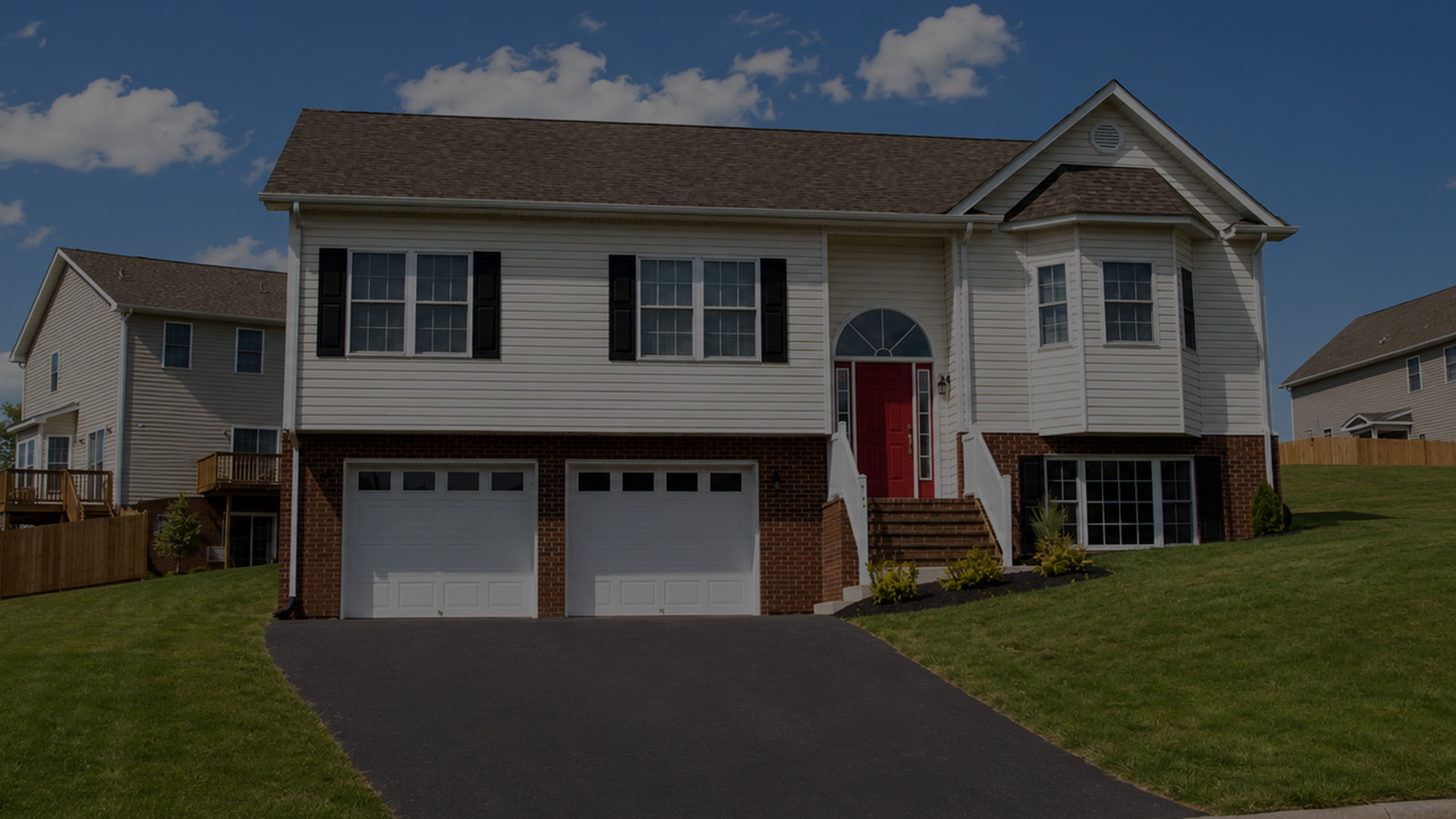 Charming suburban home with elegant red front door, twin garages, and landscaped front yard.