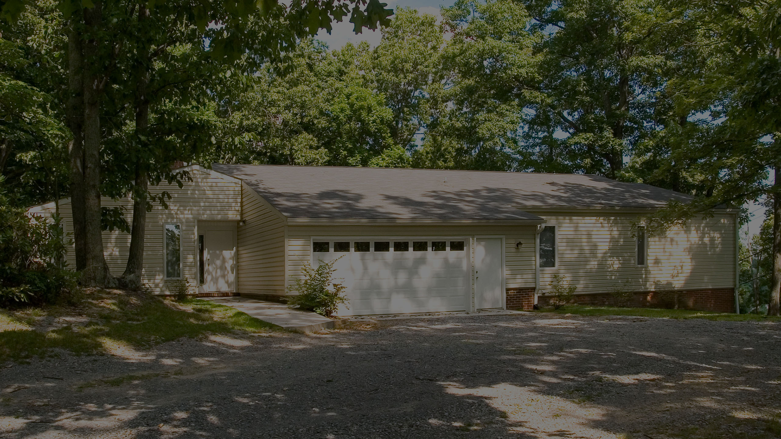 Charming single-story home with a spacious two-car garage nestled among lush greenery.