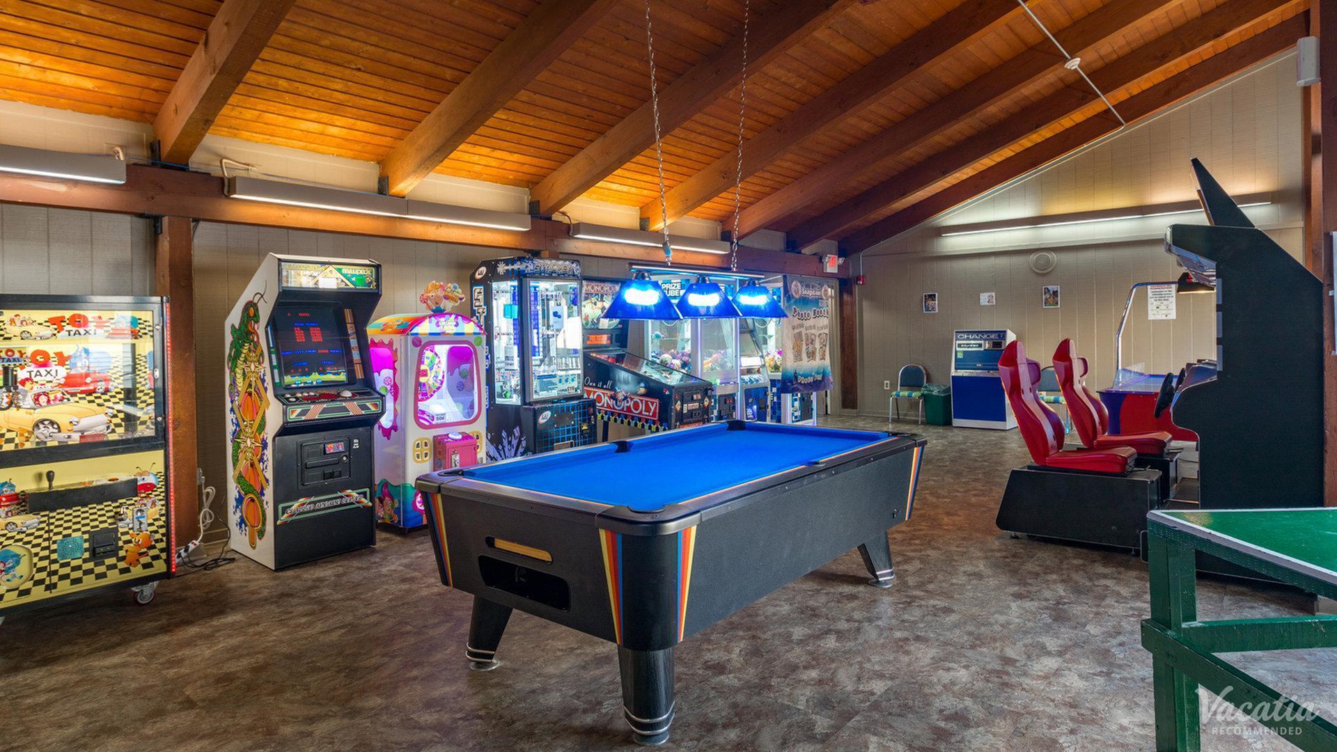 Inviting recreational room featuring a vibrant pool table, arcade games, and racing simulators, perfect for leisure and fun.
