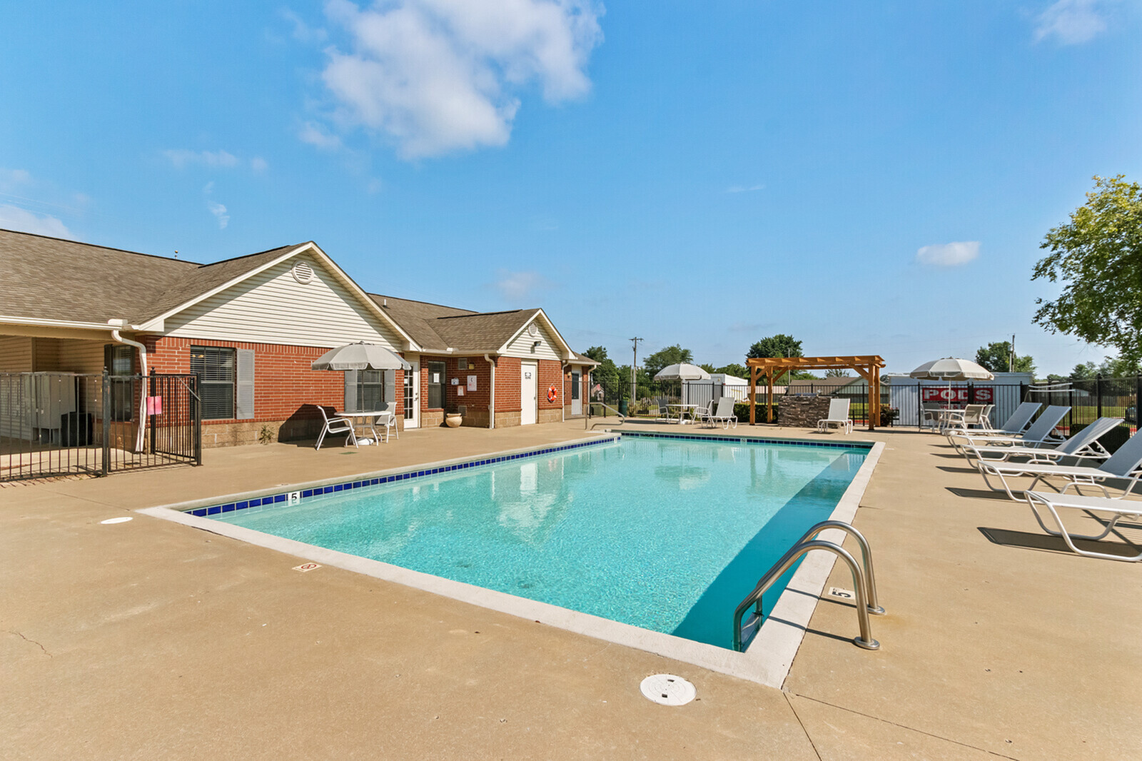 Inviting outdoor pool area with sparkling blue water, surrounded by comfortable lounge chairs and shaded umbrellas, perfect for relaxation and leisure.