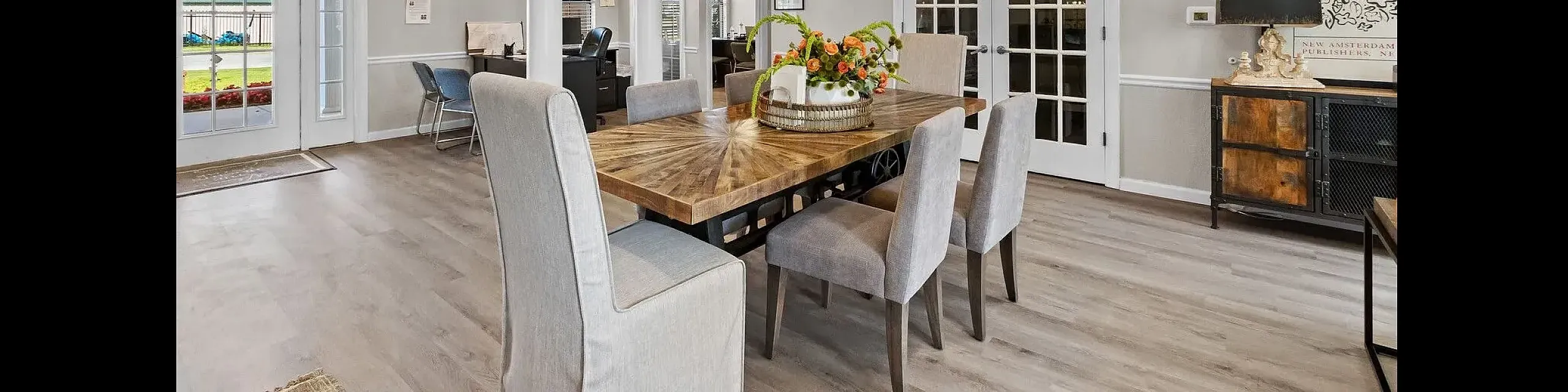 The Heights on Oak clubhouse featuring a large wooden dining table, elegant decor, and modern community workspace in Springdale, Arkansas.