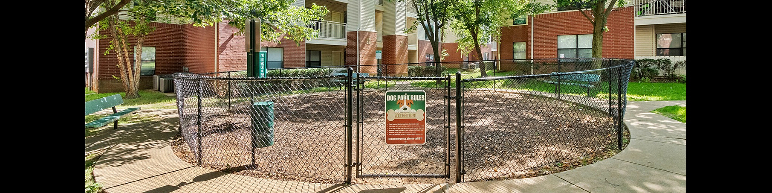 Inviting apartment complex featuring lush greenery, shaded walkways, and a welcoming dog park.