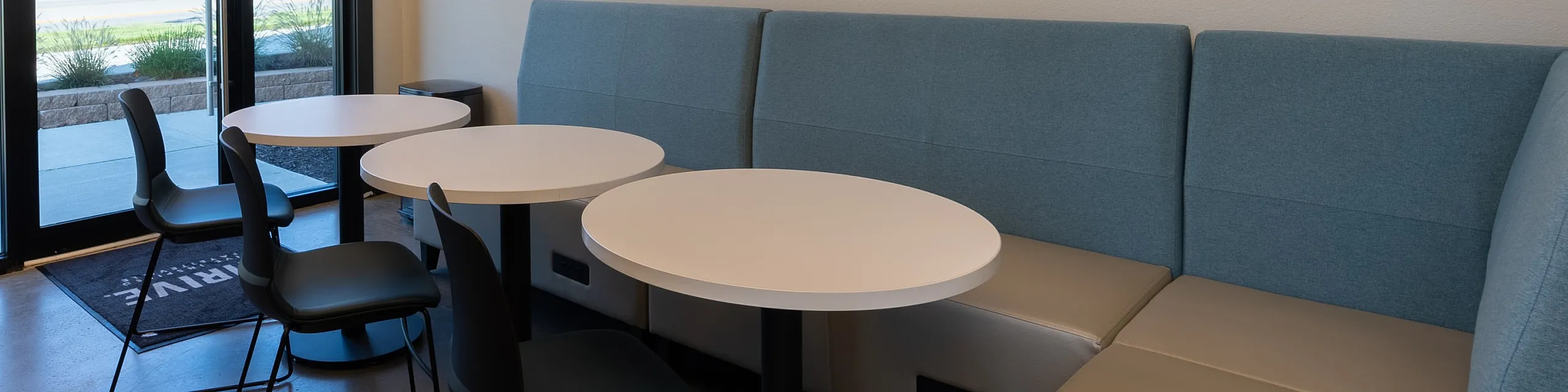 Modern and inviting communal space with elegant pendant lighting, sleek round tables, and comfortable seating, perfect for social gatherings or relaxation.