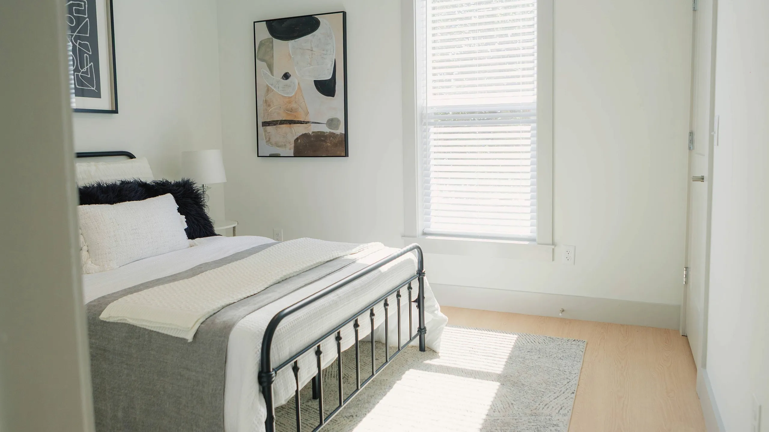 Bright and airy bedroom with modern decor, featuring a cozy bed and warm natural light.