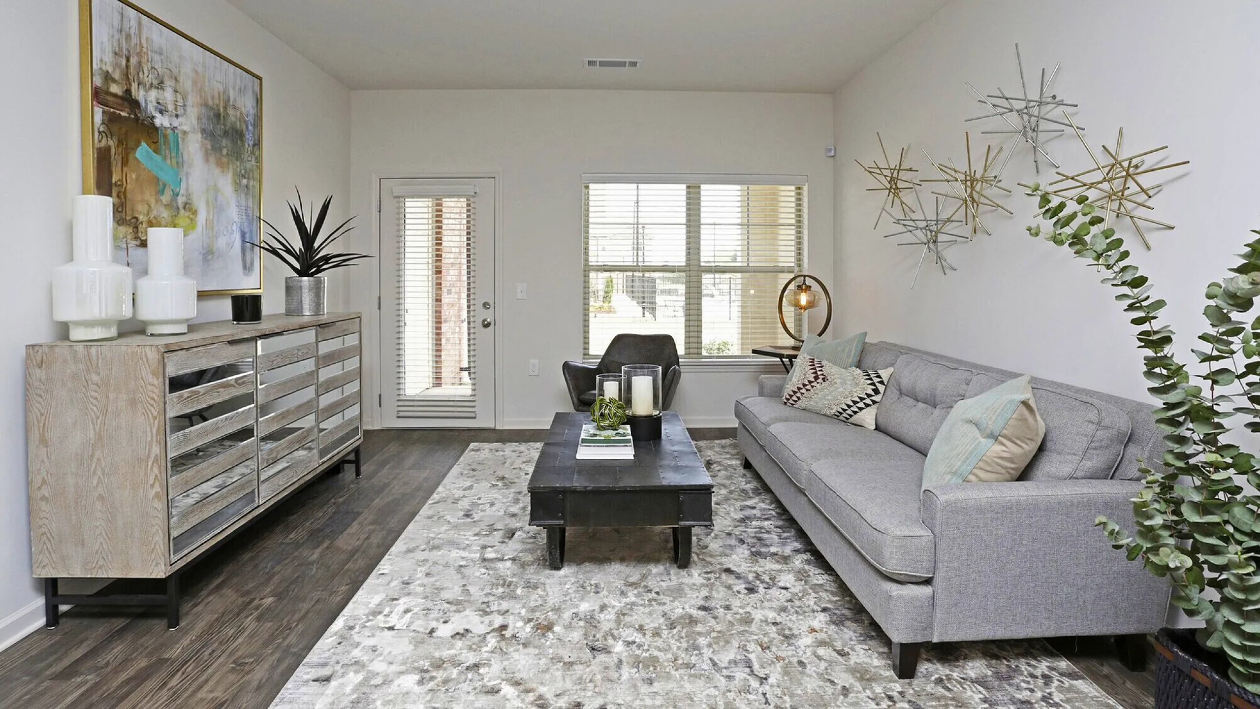 Chic modern living room with elegant gray sofa, artistic wall decor, and cozy ambiance, perfect for relaxation.