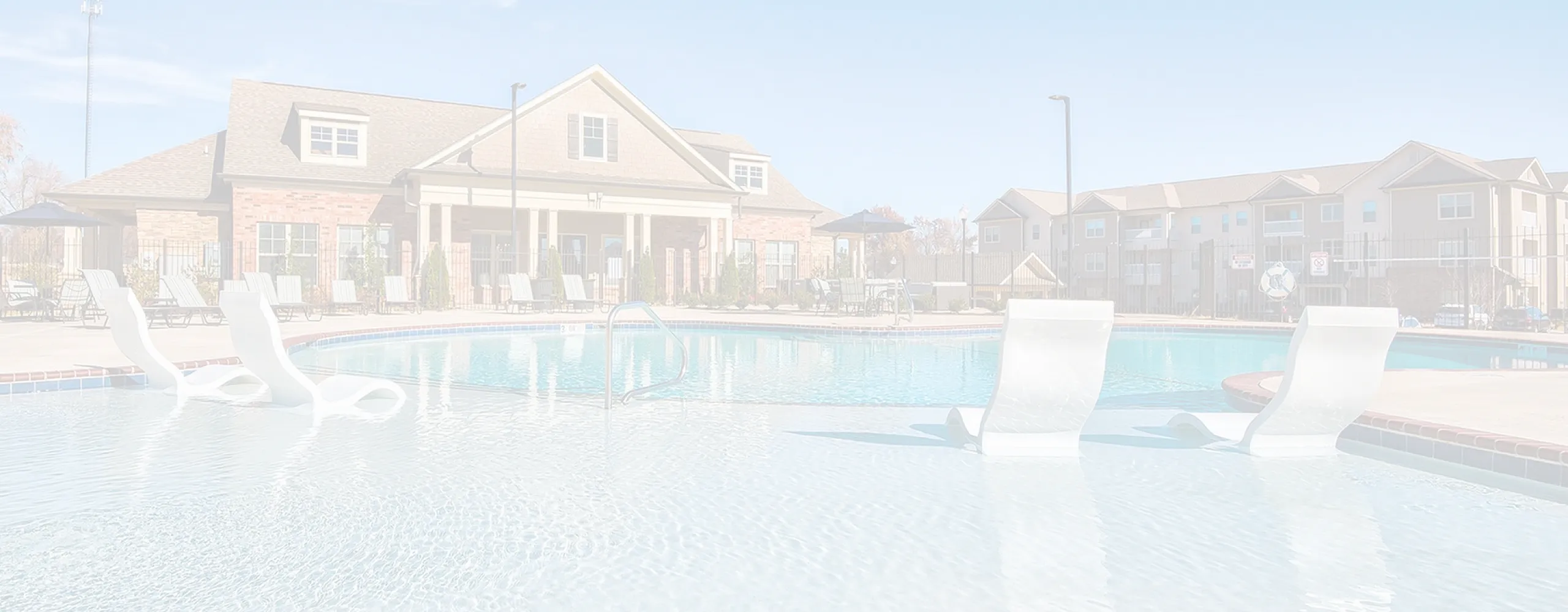 Inviting community pool area with elegant sun loungers and stylish clubhouse backdrop, perfect for relaxation and recreation.