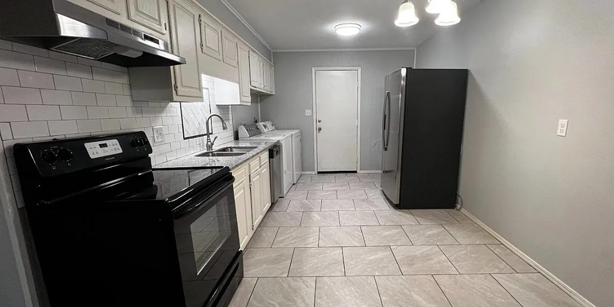 Elegant kitchen with modern appliances, sleek white cabinetry, and a spacious layout with tiled flooring.