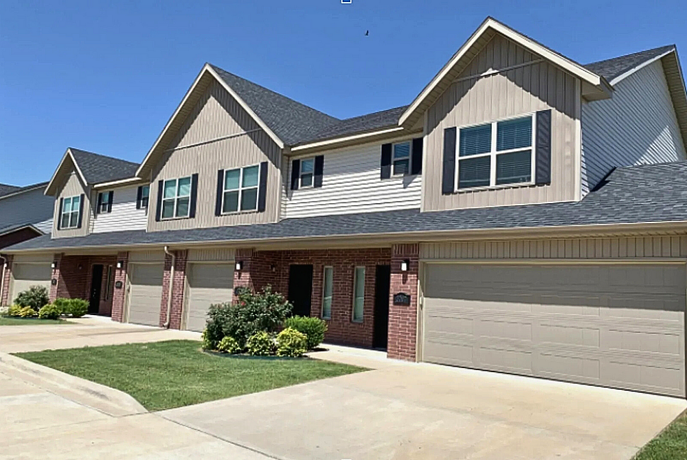 Charming suburban townhouse with a modern design and dual garages, set in a peaceful neighborhood.