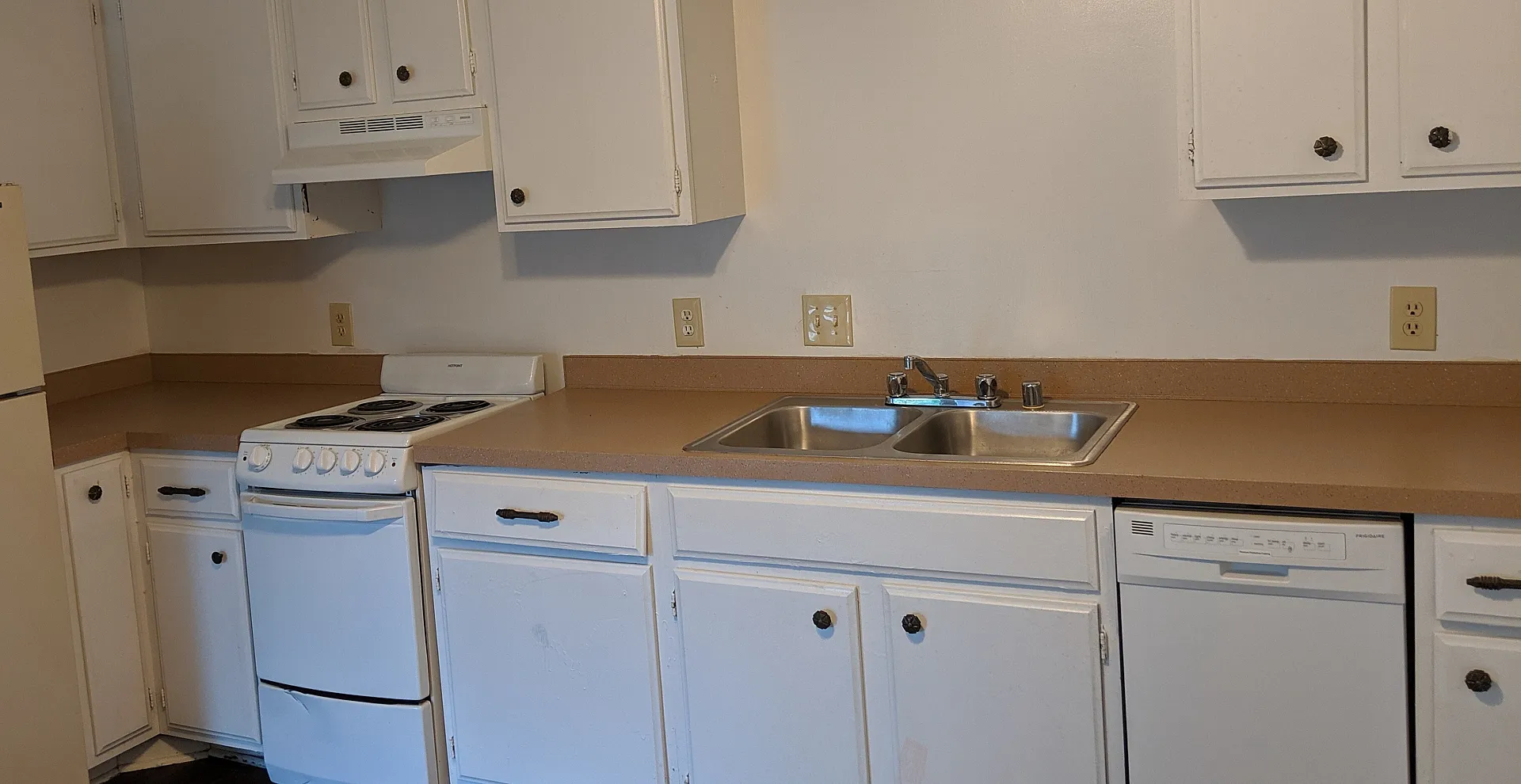 Charming kitchen with classic white cabinetry, dual sinks, and modern appliances, perfect for culinary inspiration.