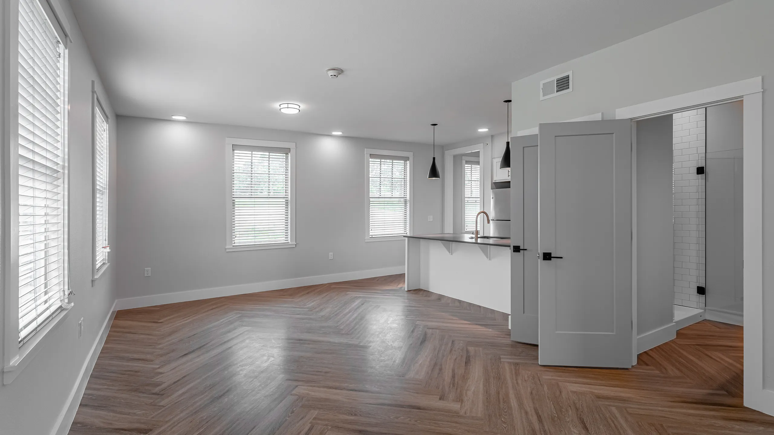Bright and modern apartment interior with sleek wood flooring, ample natural light, and a contemporary open-concept design.