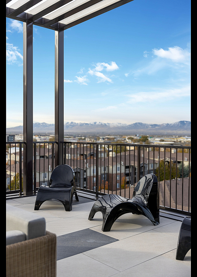 Luxurious rooftop terrace with modern black chairs showcasing stunning panoramic mountain views.