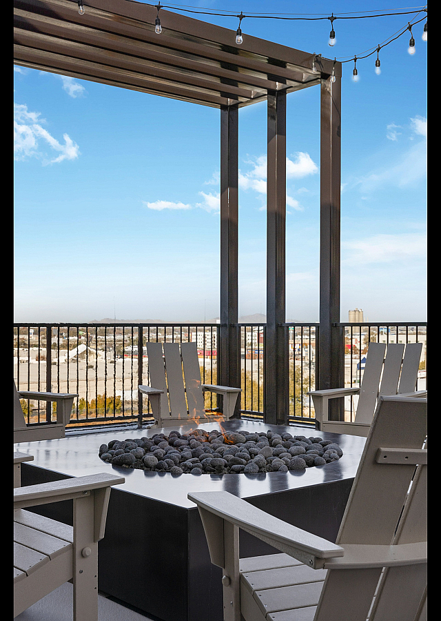 Chic rooftop patio with modern fire pit and comfortable seating offering panoramic city views.