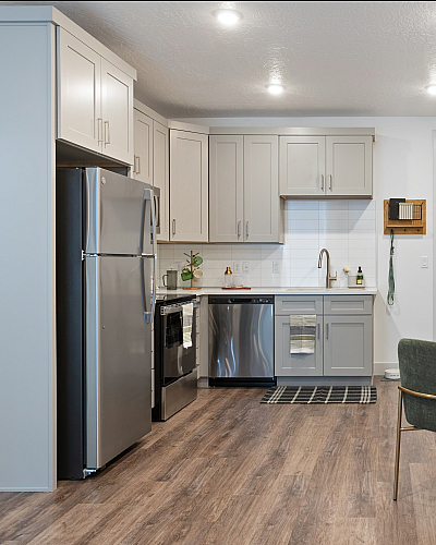 Contemporary open kitchen and dining area featuring sleek cabinetry, stainless steel appliances, and elegant wood flooring.