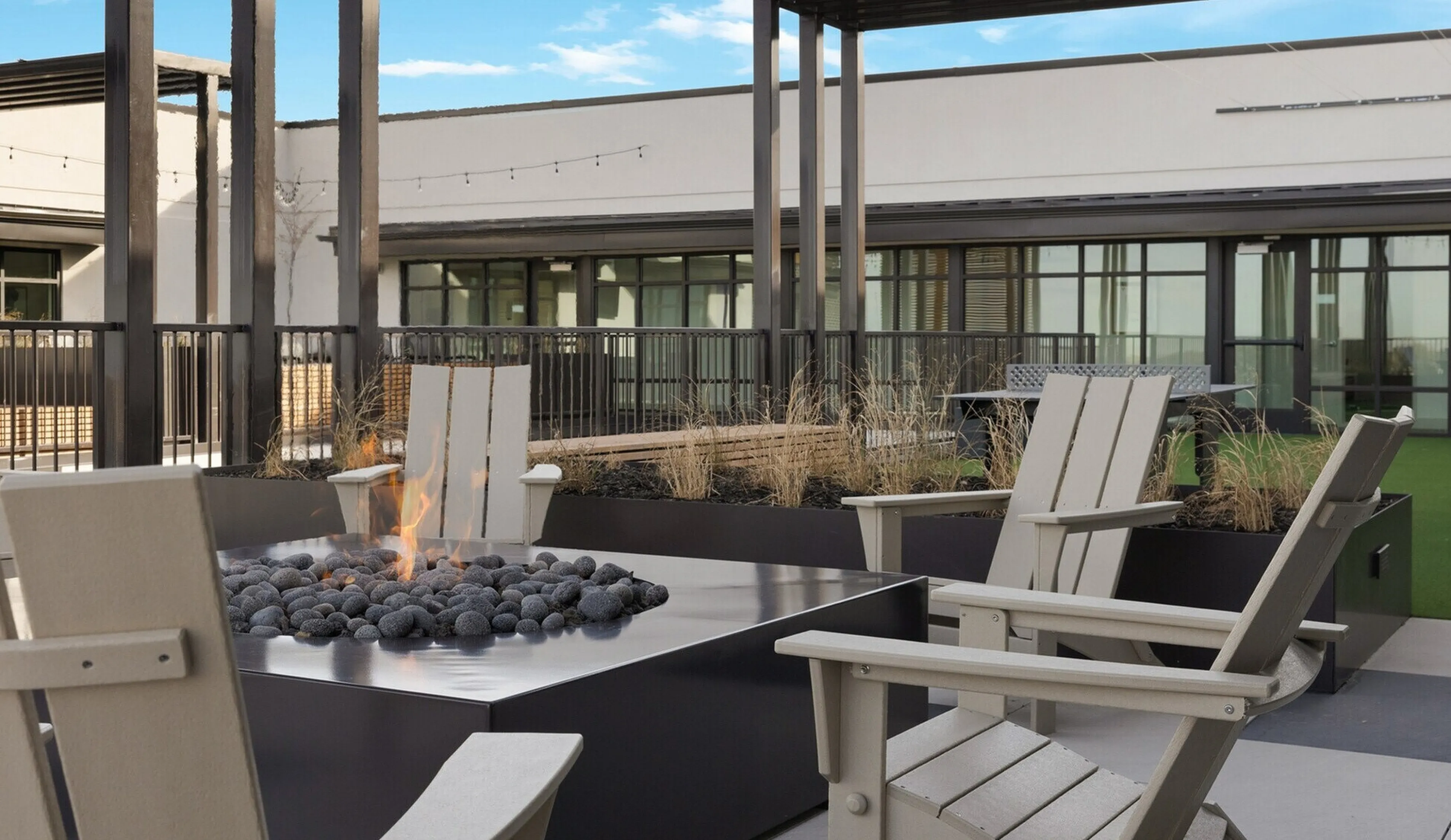 Inviting rooftop terrace with cozy fire pit, stylish seating, and modern architectural design, perfect for relaxation and social gatherings.
