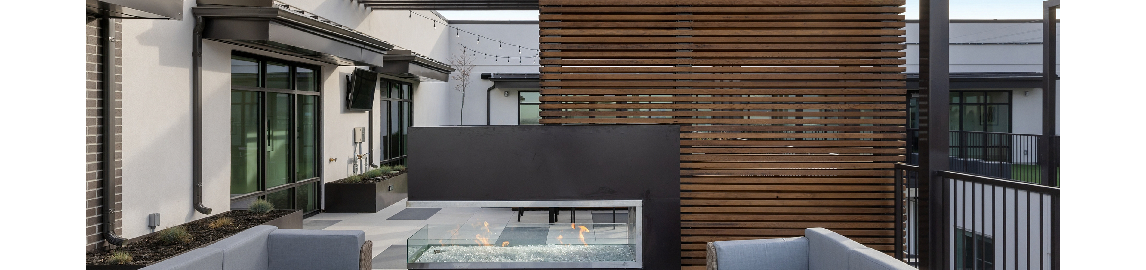 Rooftop lounge with a glass fireplace, cedar privacy screen and lounge seating