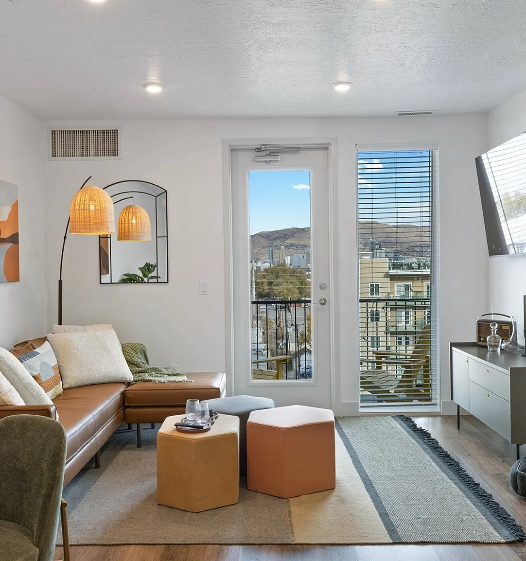 Bright apartment living room with balcony doors and mountain views at Tradition Pointe