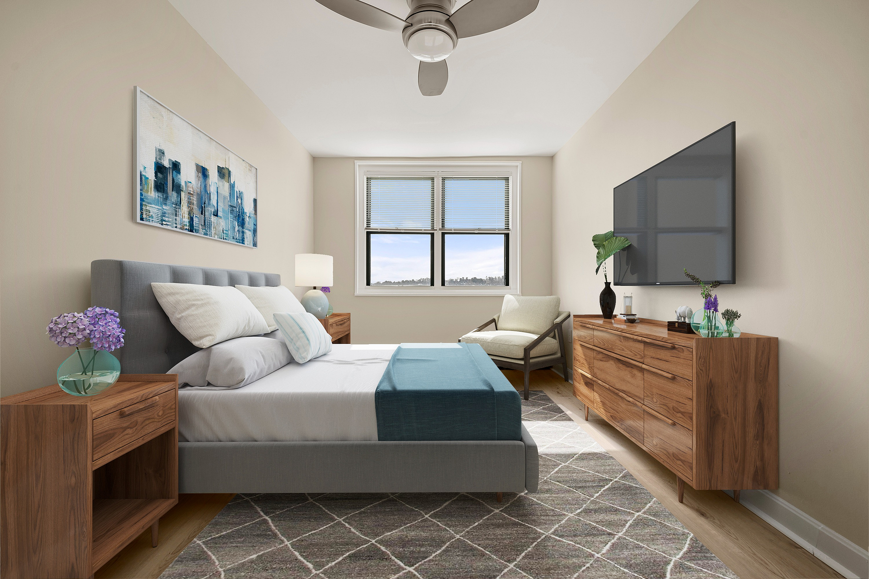 Bright, modern bedroom featuring a plush grey bed, mid-century wooden furniture, and a large window with a scenic view.