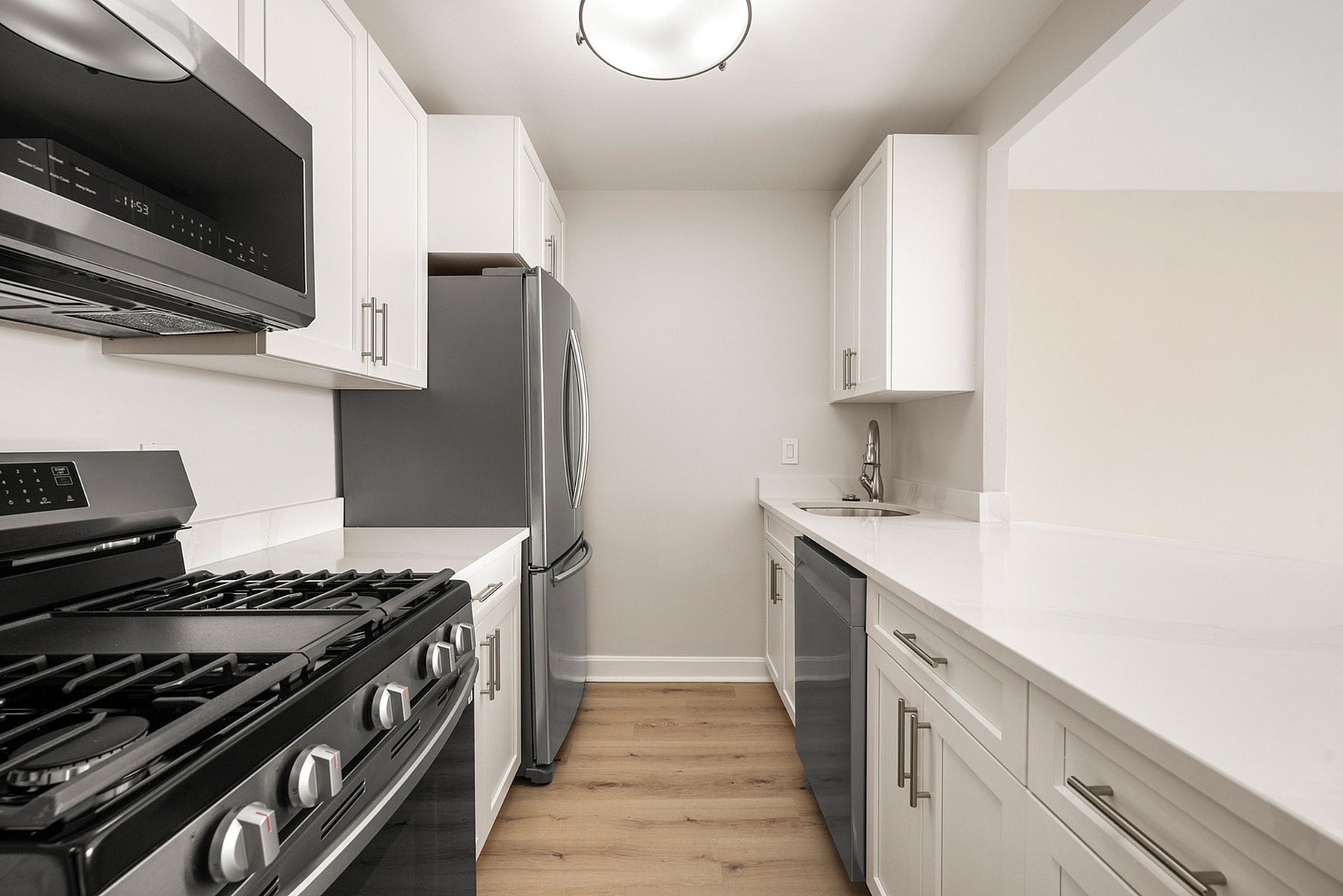Sleek modern kitchen with stainless steel appliances, elegant white cabinetry, and polished countertops, offering a stylish and functional space.