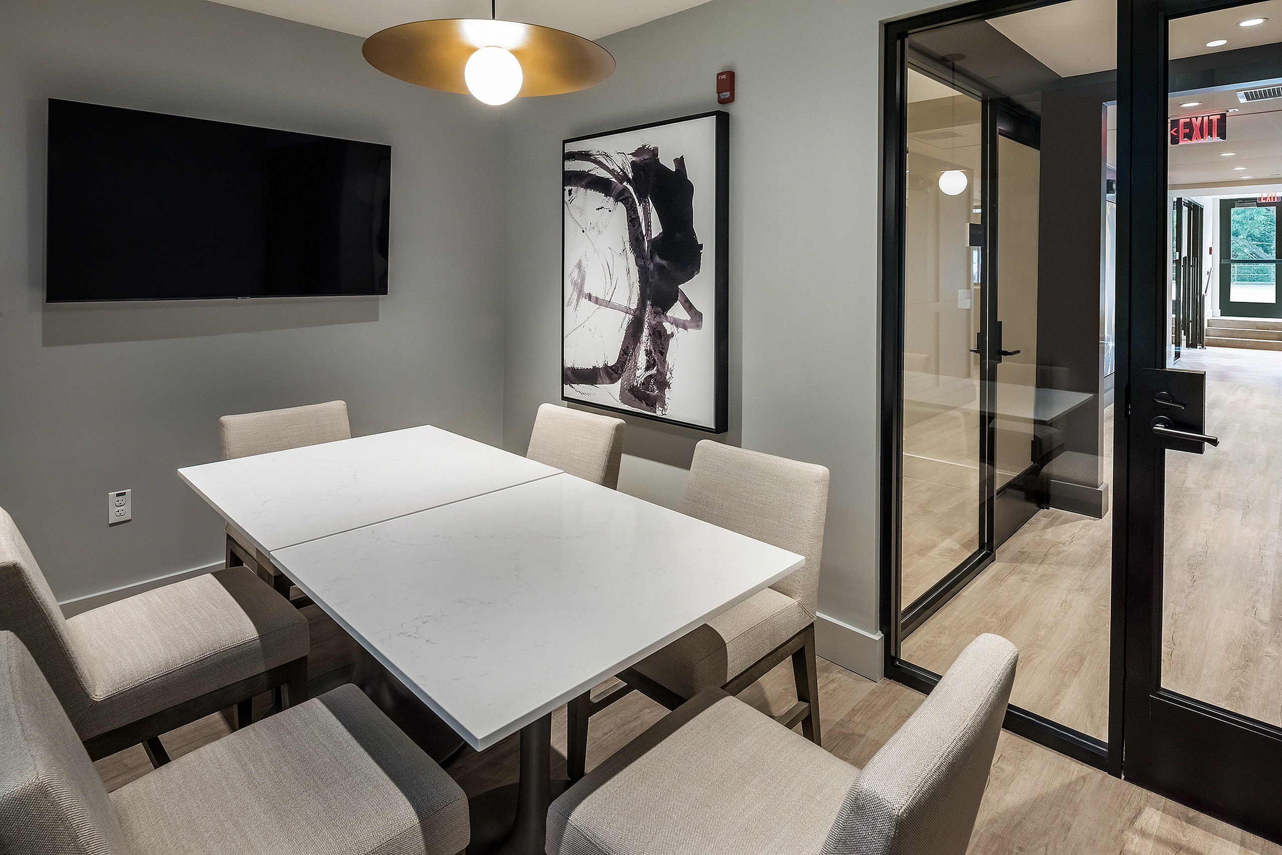 Modern conference room with sleek table, comfortable chairs, and stylish artwork, perfect for productive meetings.