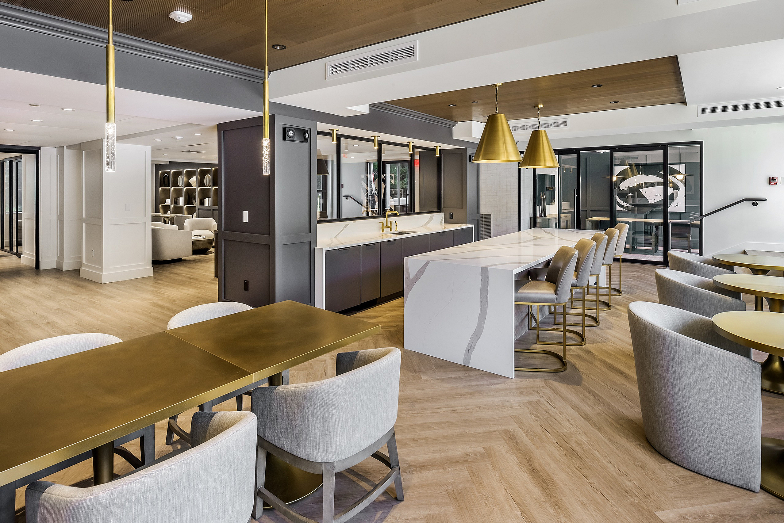 Elegant and modern communal area featuring luxurious seating, a sleek bar, and stylish pendant lighting.