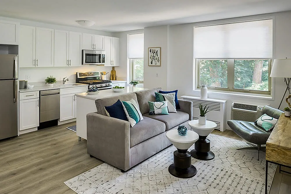 Modern open-concept living room and kitchen with sleek white cabinetry, stylish decor, and a cozy sofa perfect for relaxation.