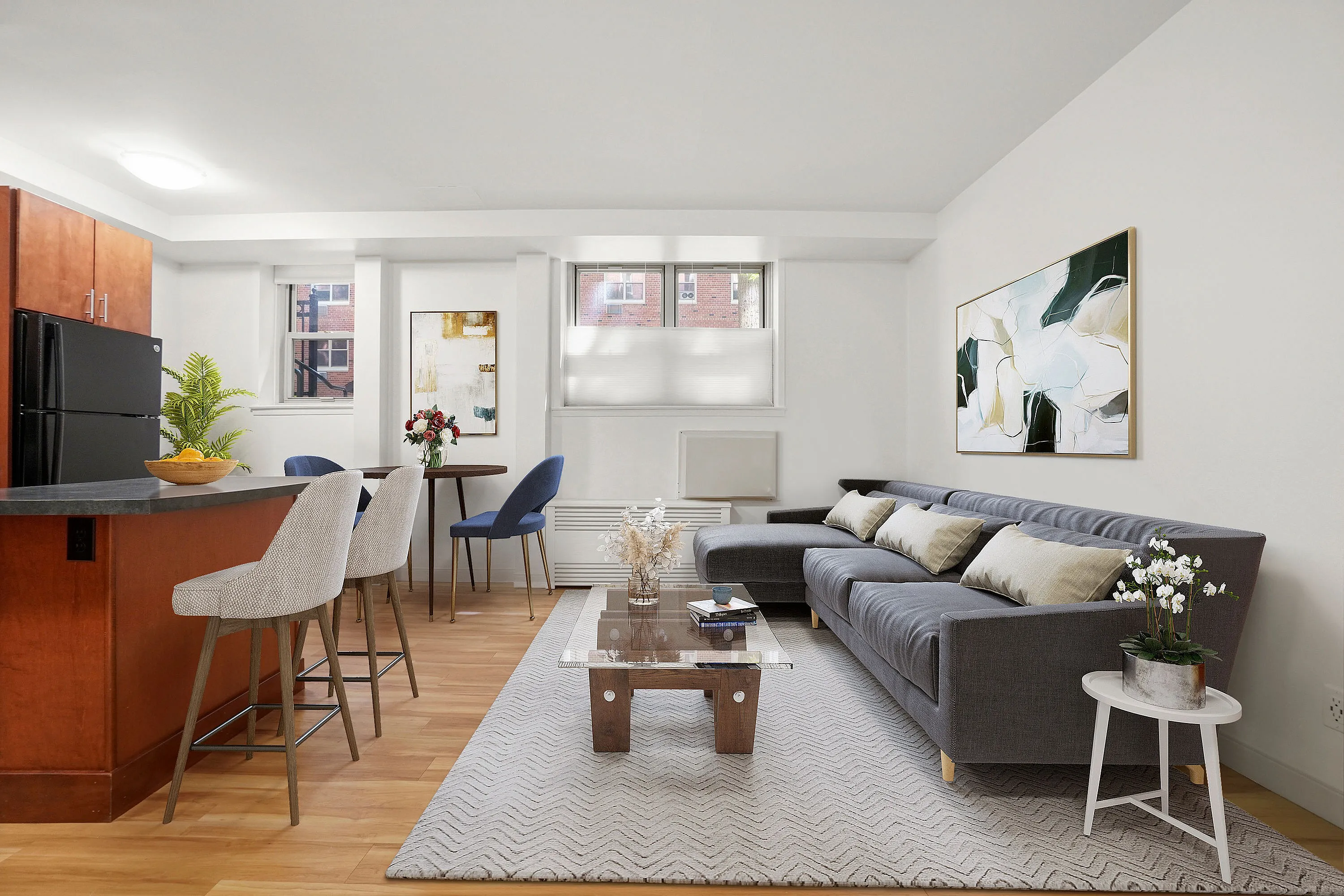 Chic, modern living space featuring a cozy gray sectional, elegant decor, and a breakfast bar with stylish seating.