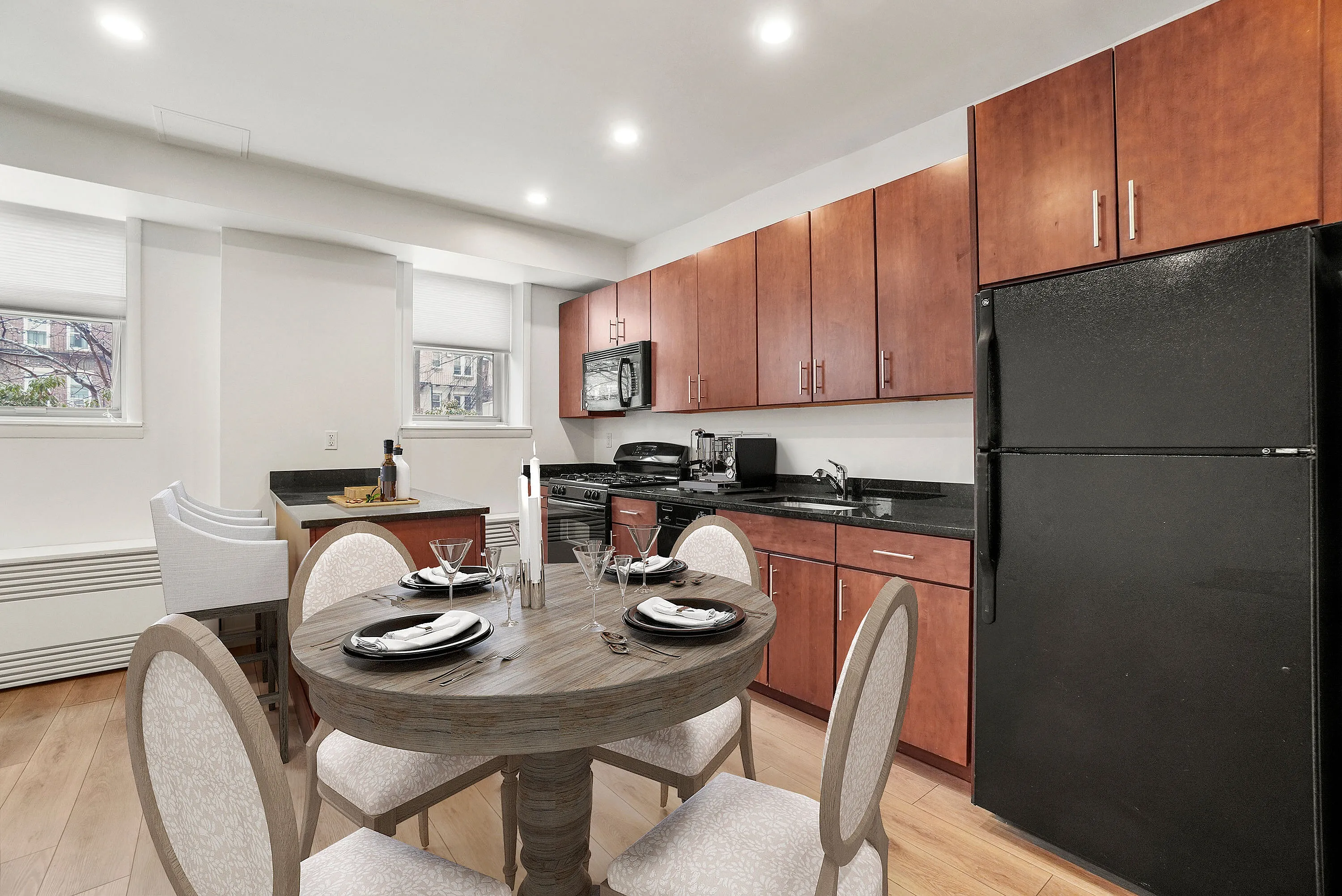 Elegant kitchen and dining area featuring modern cabinetry, sleek granite countertops, and a stylish round dining table set for four.