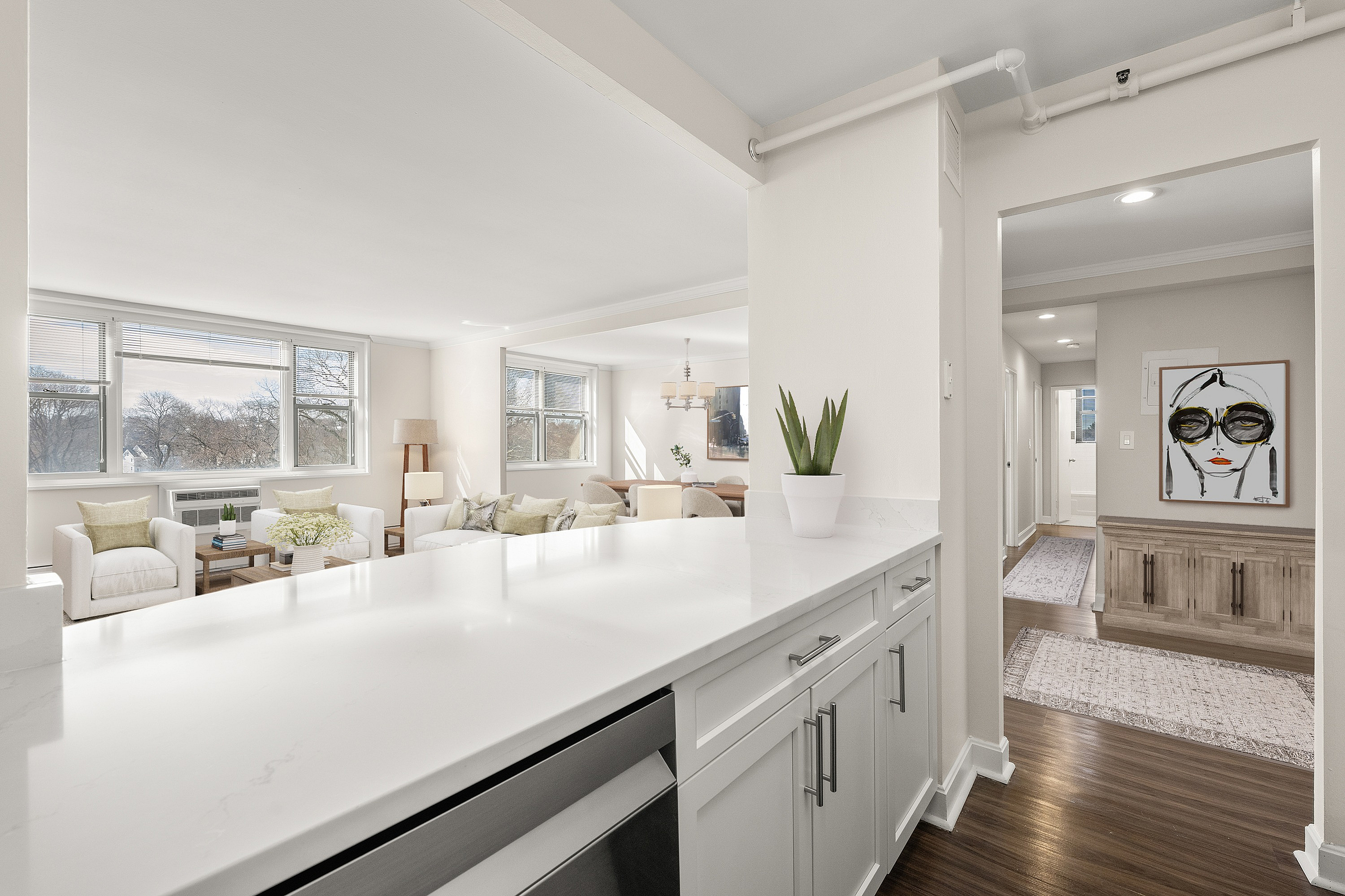 Bright and inviting living space with elegant decor, large windows, and modern kitchen counter detail.