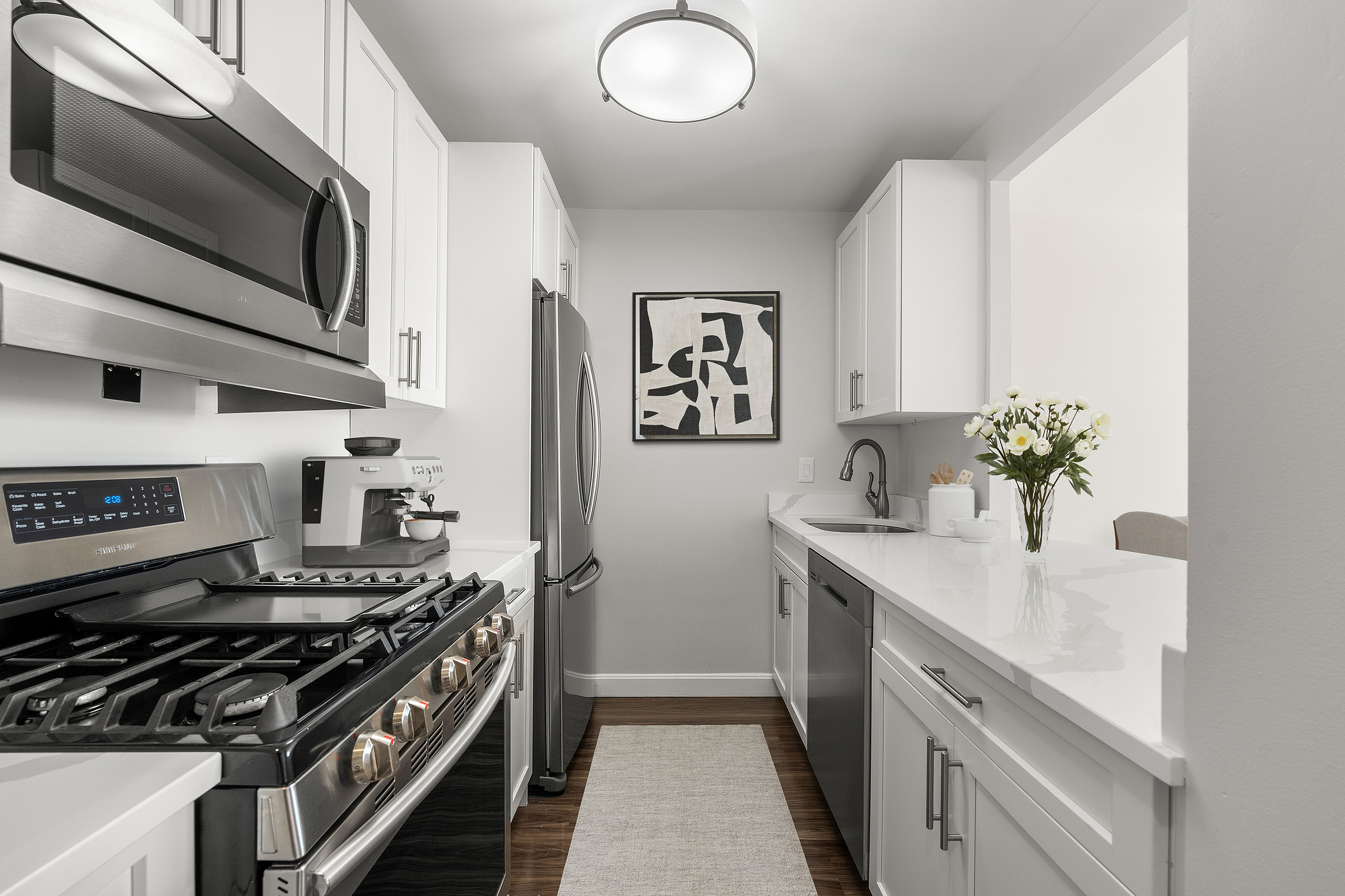 Sleek modern kitchen featuring stainless steel appliances, contemporary cabinetry, and elegant quartz countertops, showcasing a bright and inviting culinary space.