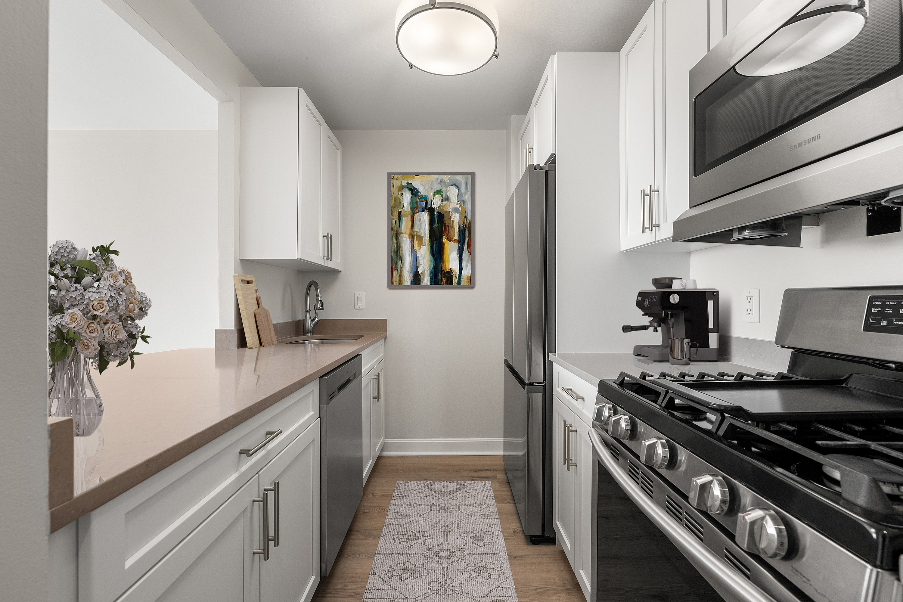 Sleek and modern kitchen with stainless steel appliances, elegant white cabinetry, and stylish artwork, offering a perfect blend of functionality and design.