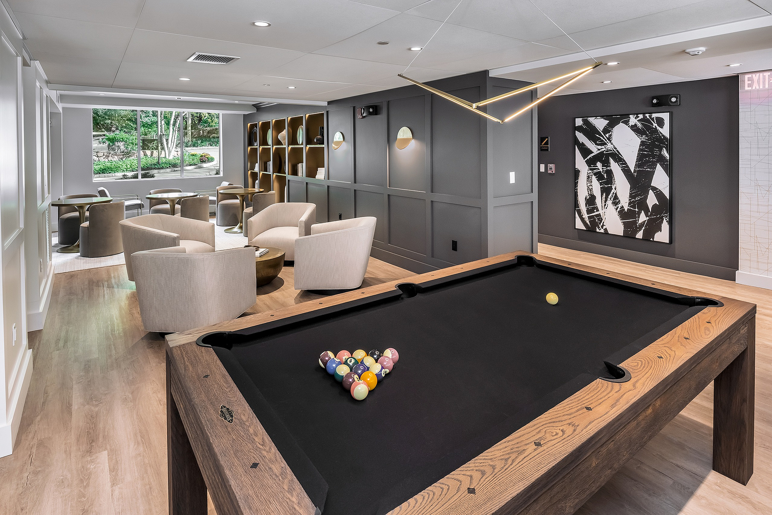 Modern lounge area with a sleek pool table, stylish seating, and contemporary decor for relaxation and entertainment.