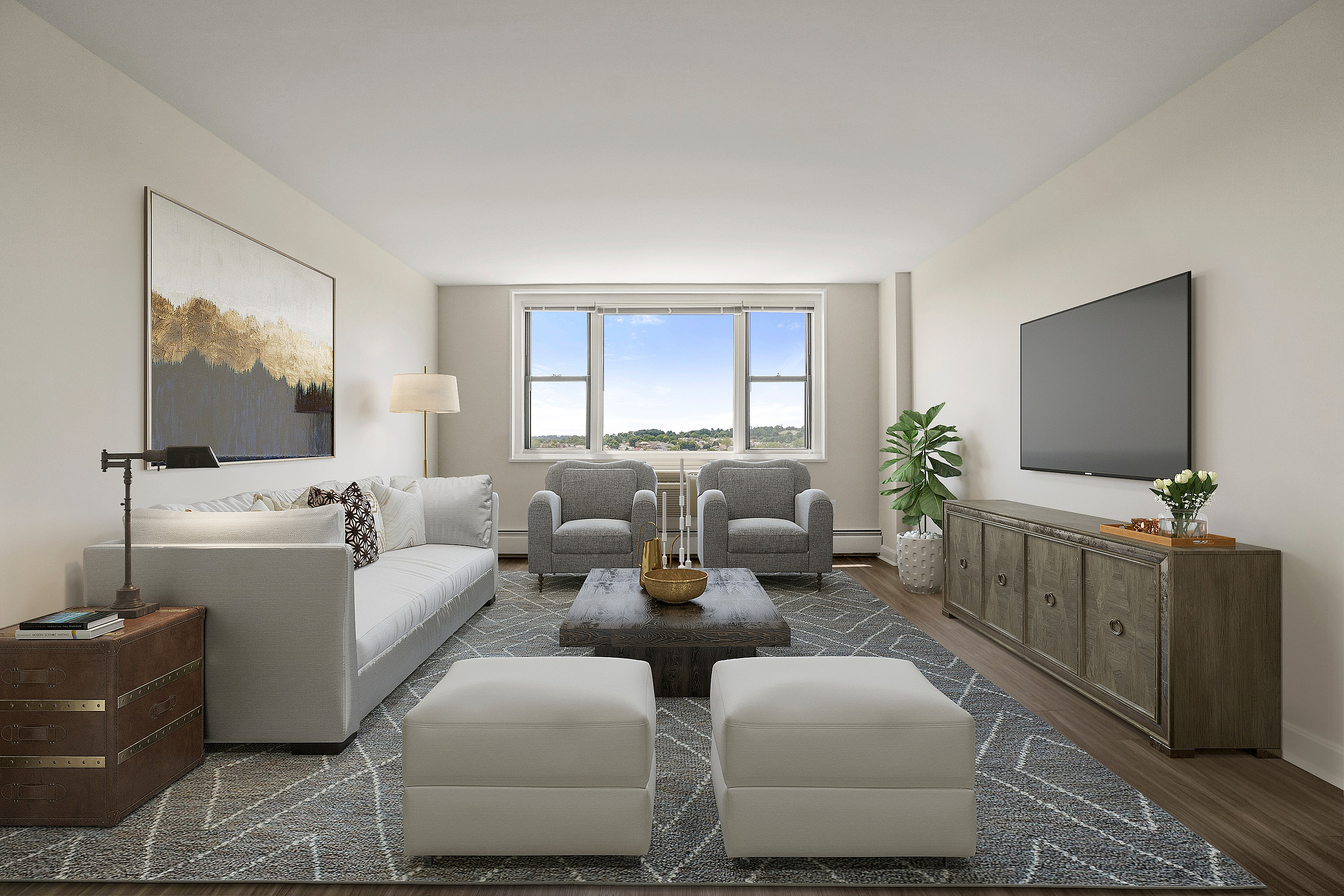 Elegant living room with plush grey sofa, modern armchairs, and floor-to-ceiling windows offering scenic views. Stylish decor and ample natural light create a welcoming atmosphere.