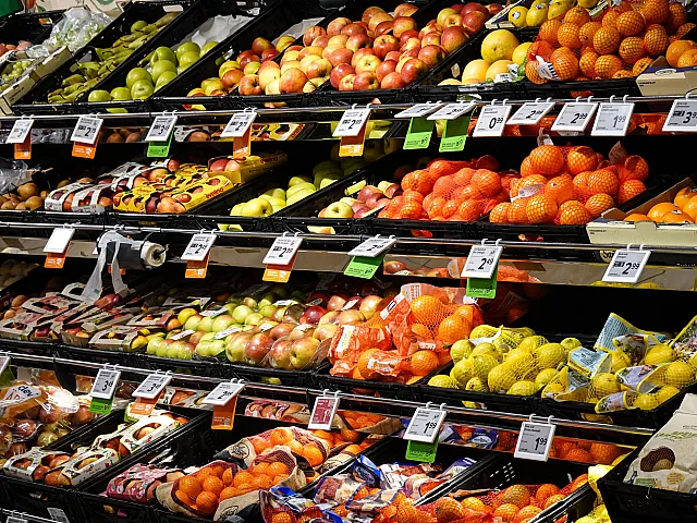 Vibrant grocery display showcasing a fresh assortment of colorful apples, oranges, and pears, enticingly arranged on a supermarket shelf.