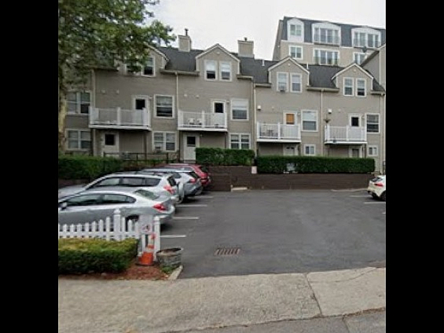 Charming multi-story building with private balconies and convenient parking in a serene neighborhood setting.