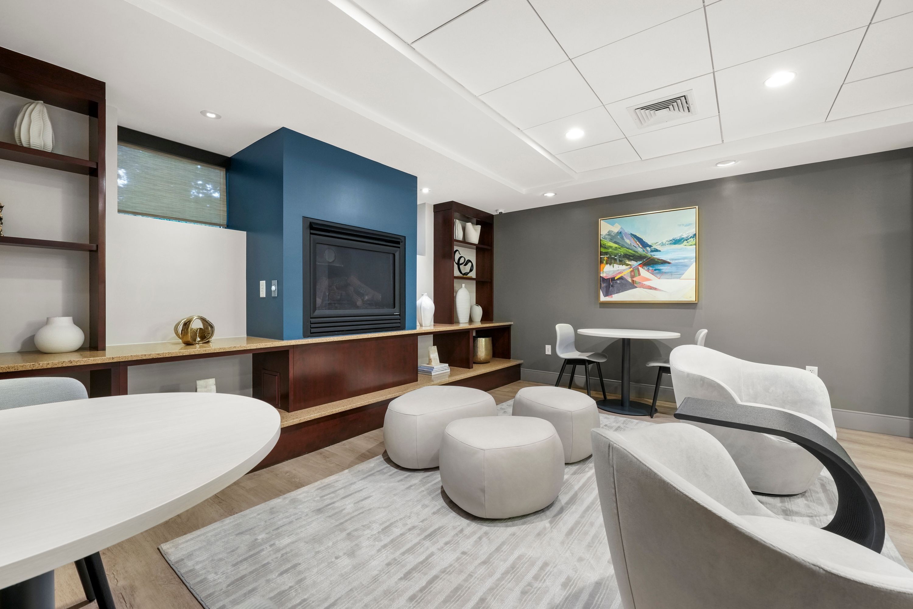 Contemporary lounge area featuring elegant seating, modern fireplace, and vibrant artwork creating a cozy ambiance.