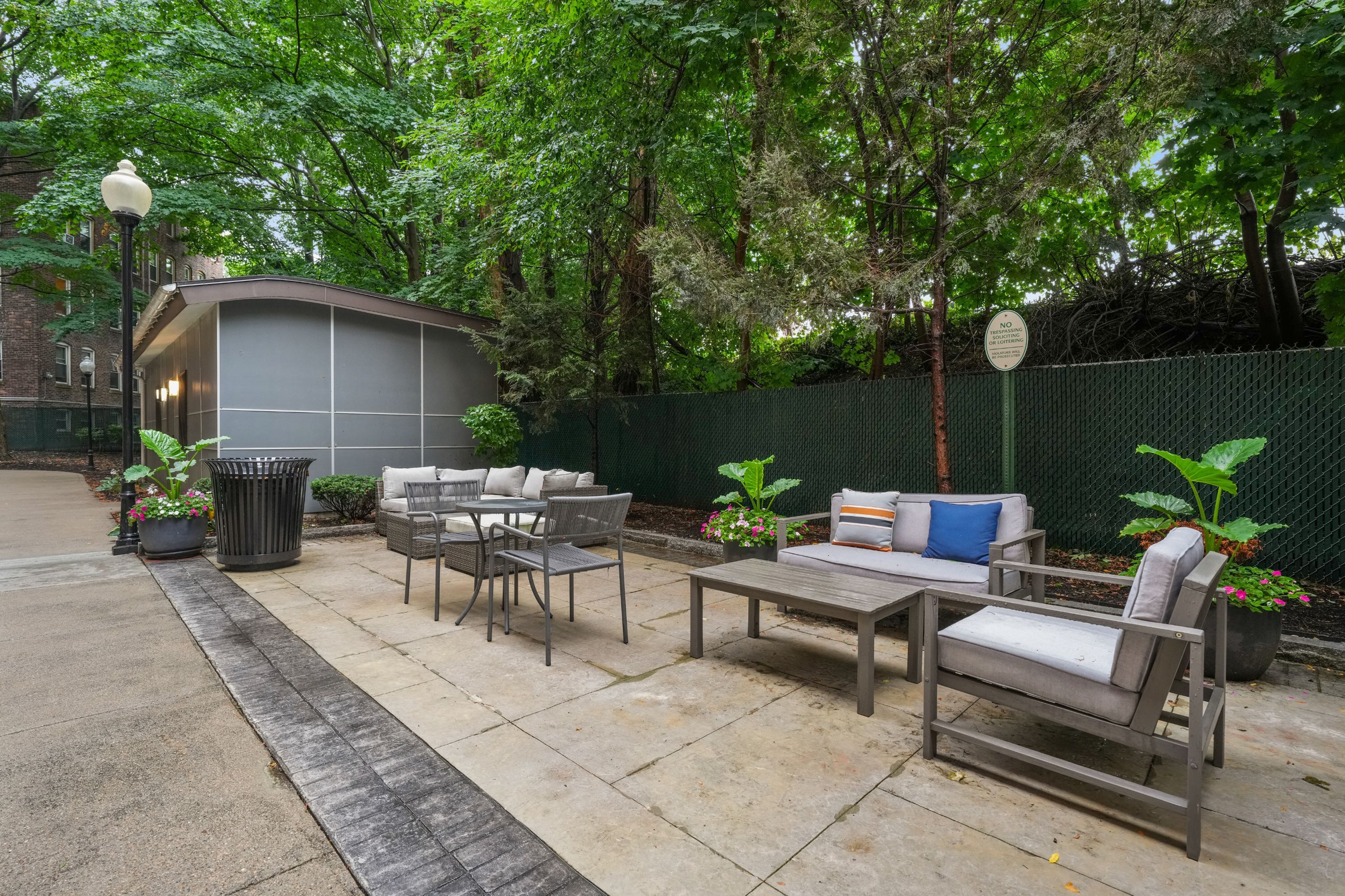 Charming outdoor patio with cozy seating and lush greenery, perfect for relaxation and gatherings.