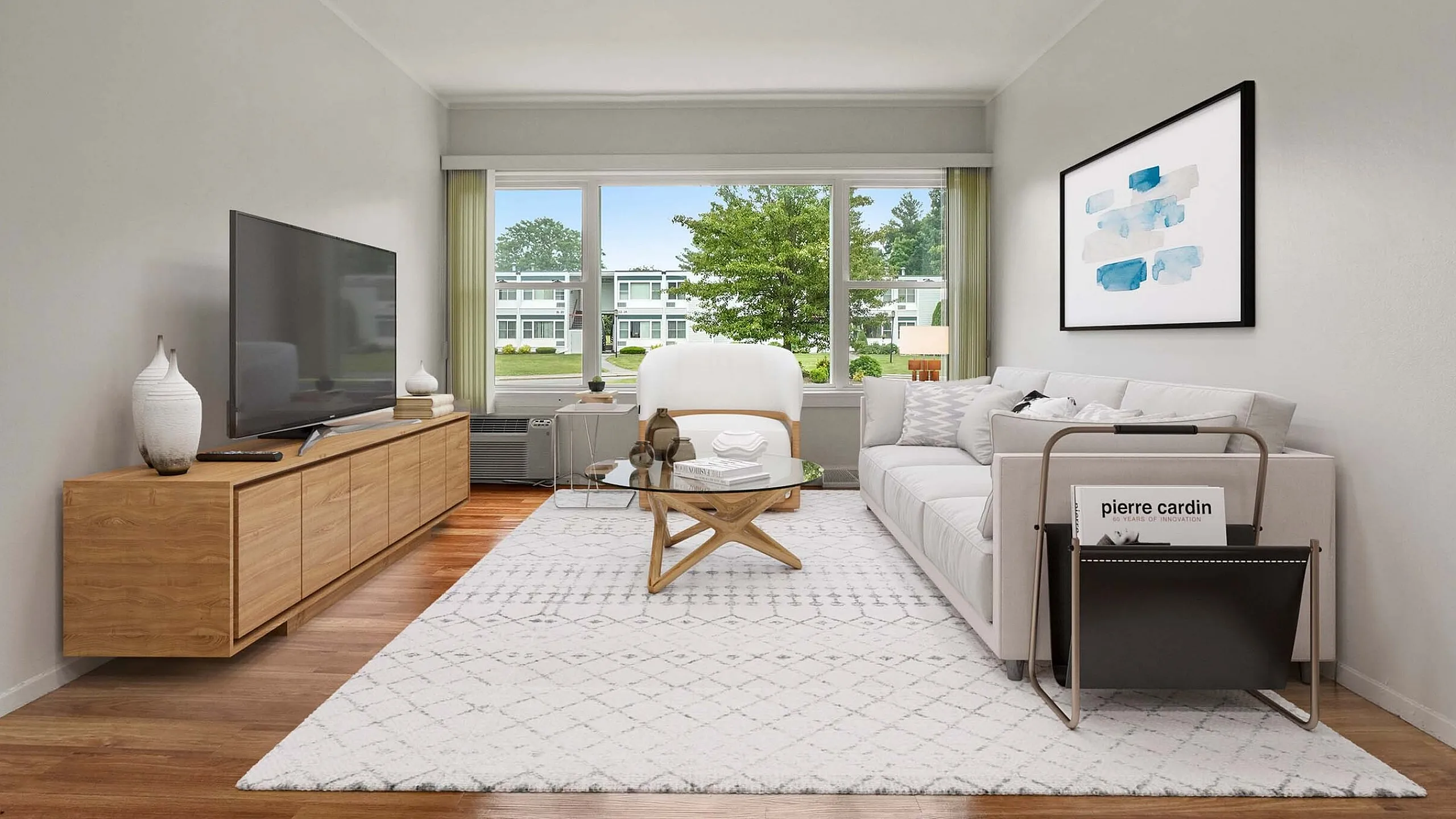 Bright and modern living room with elegant decor, featuring a large window overlooking serene greenery, cozy sofa, sleek TV stand, and contemporary artwork.