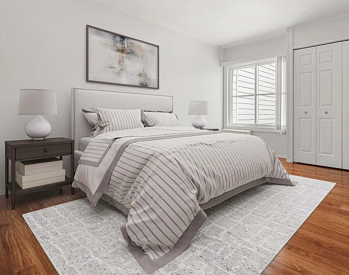 Elegant bedroom with striped bedding, large window, and polished wooden floors, creating a serene and inviting atmosphere.