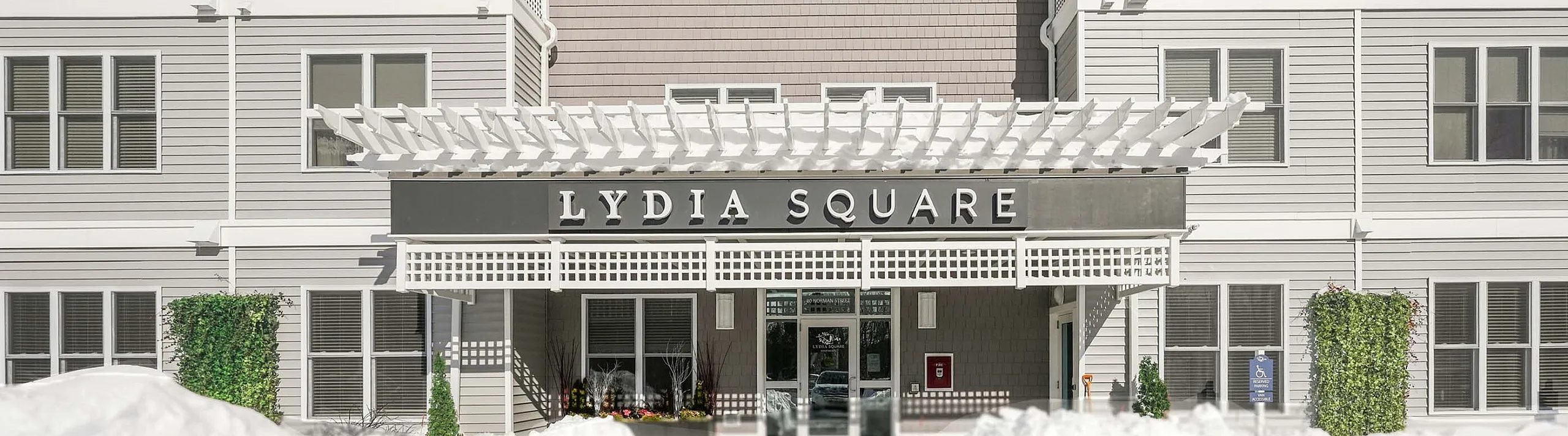 Elegant exterior of Lydia Square with modern architecture, snow-covered surroundings, and a welcoming entrance.