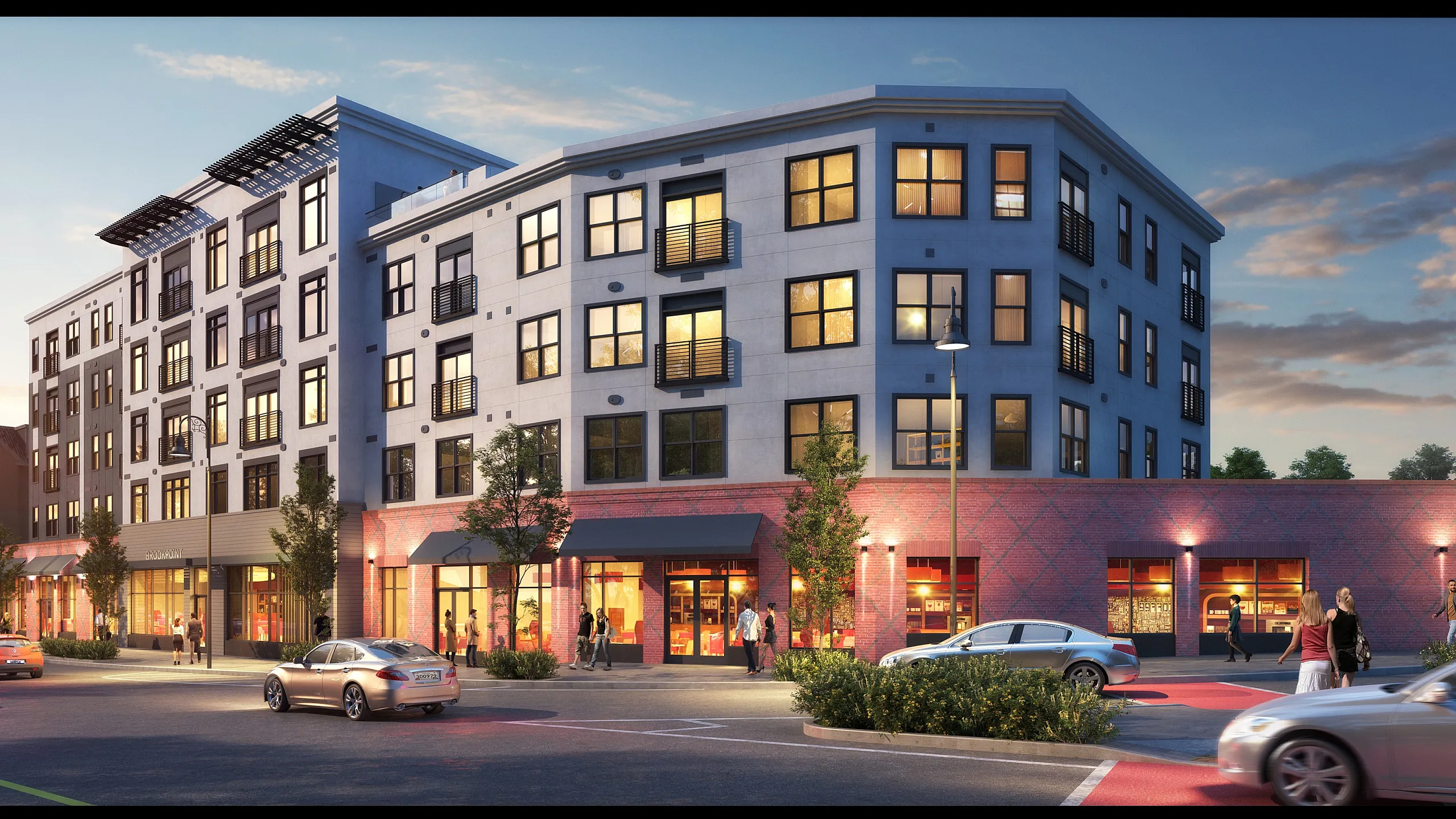 Modern apartment building at dusk with illuminated storefronts and lively street activity, featuring sleek architectural design and large windows.
