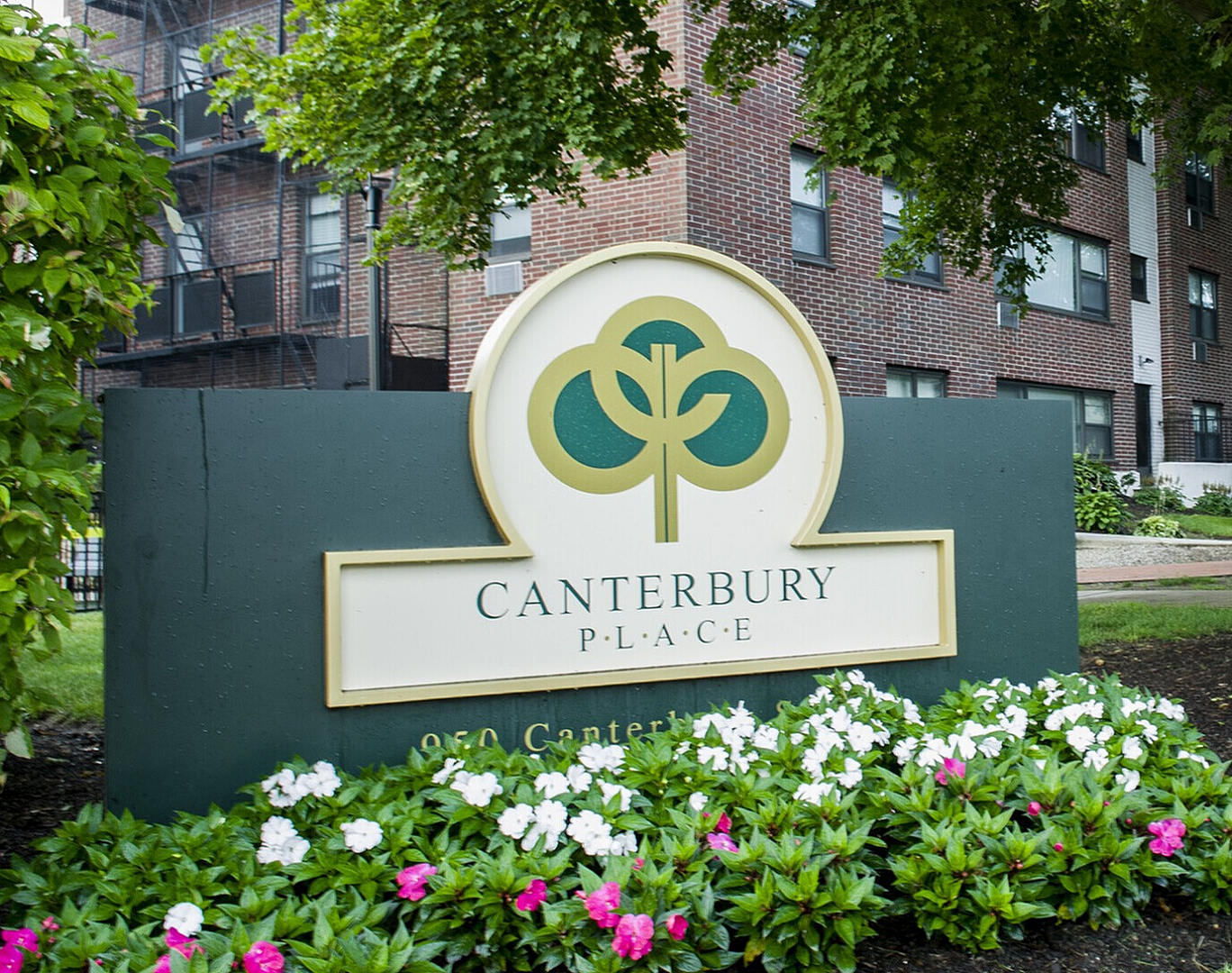 Charming exterior view of Canterbury Place featuring lush greenery, vibrant flowers, and welcoming pathways.