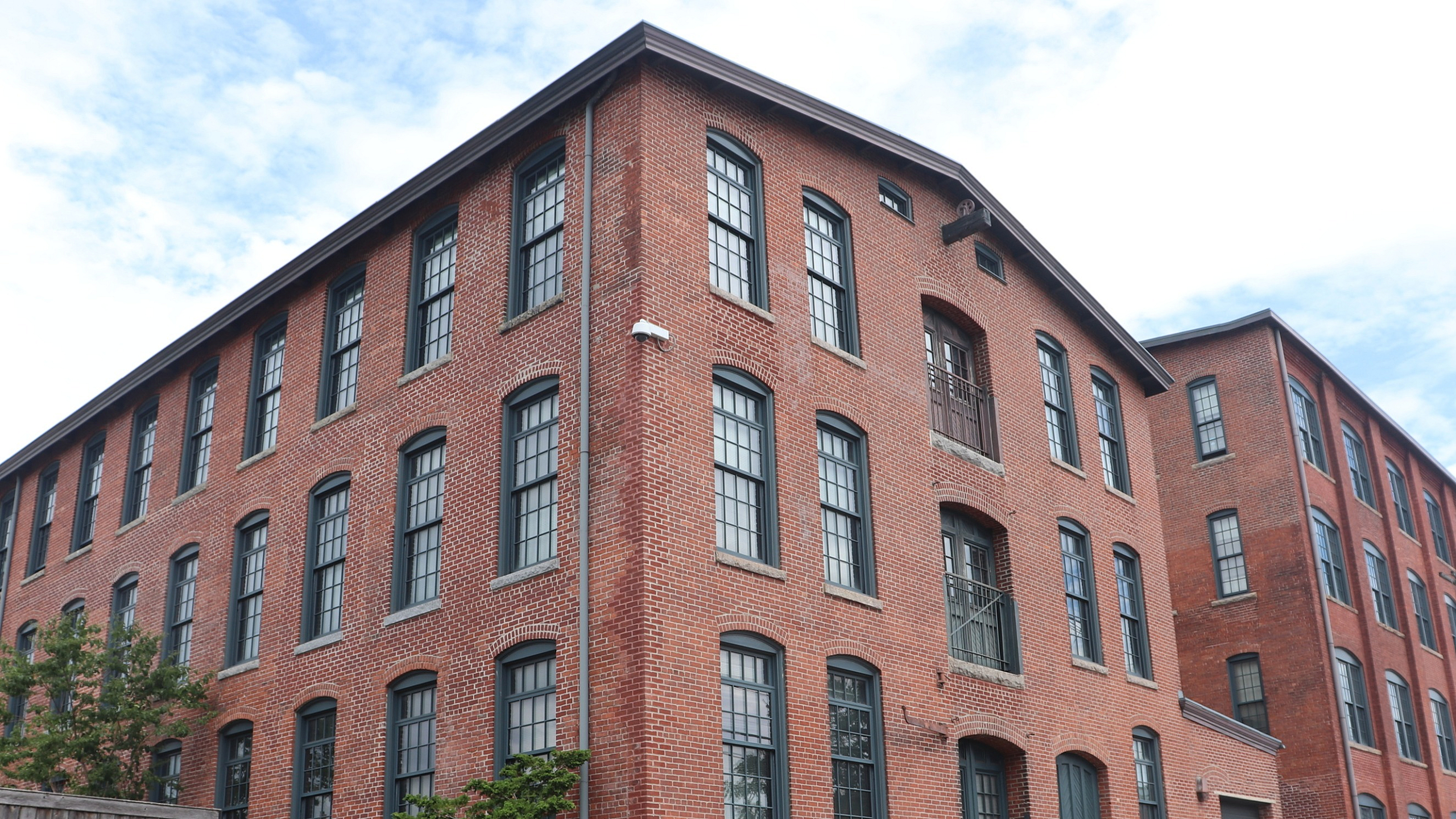 Charming red brick apartment complex with large windows, combining historic elegance and modern urban living.