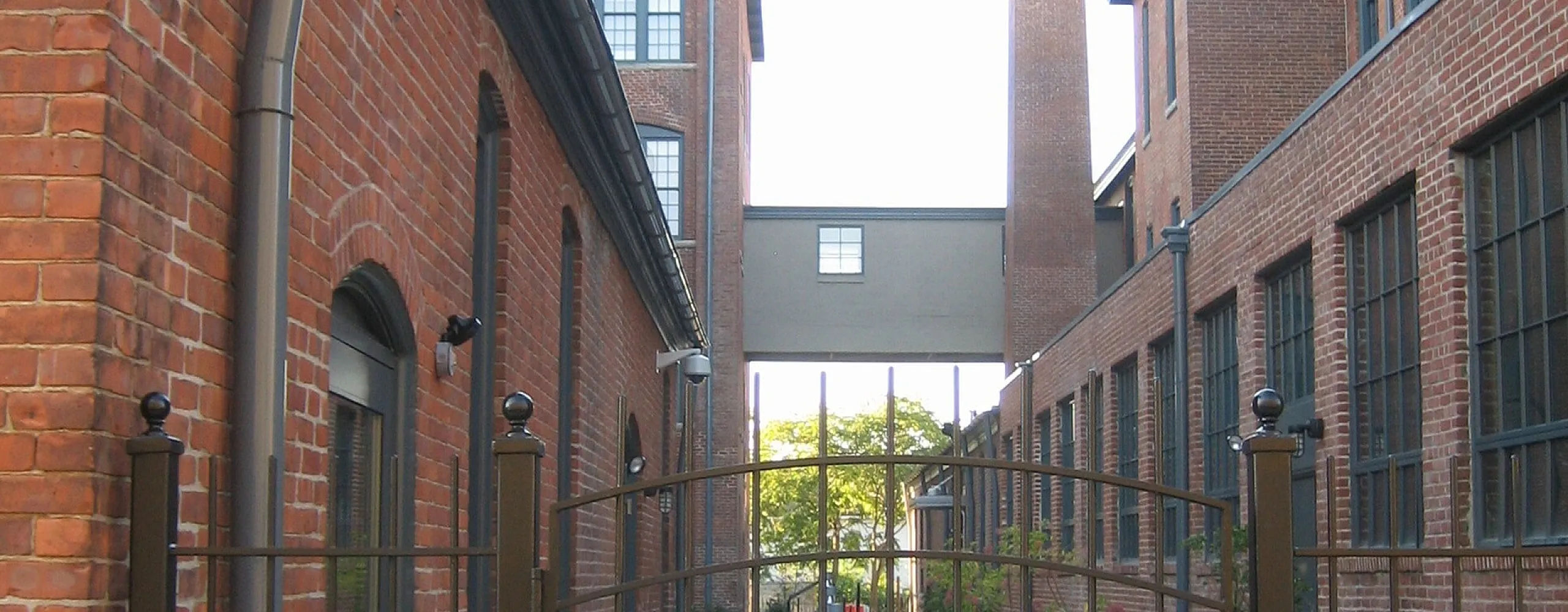 Charming brick loft apartment entrance with a gated pathway, blending historic elegance and urban living.