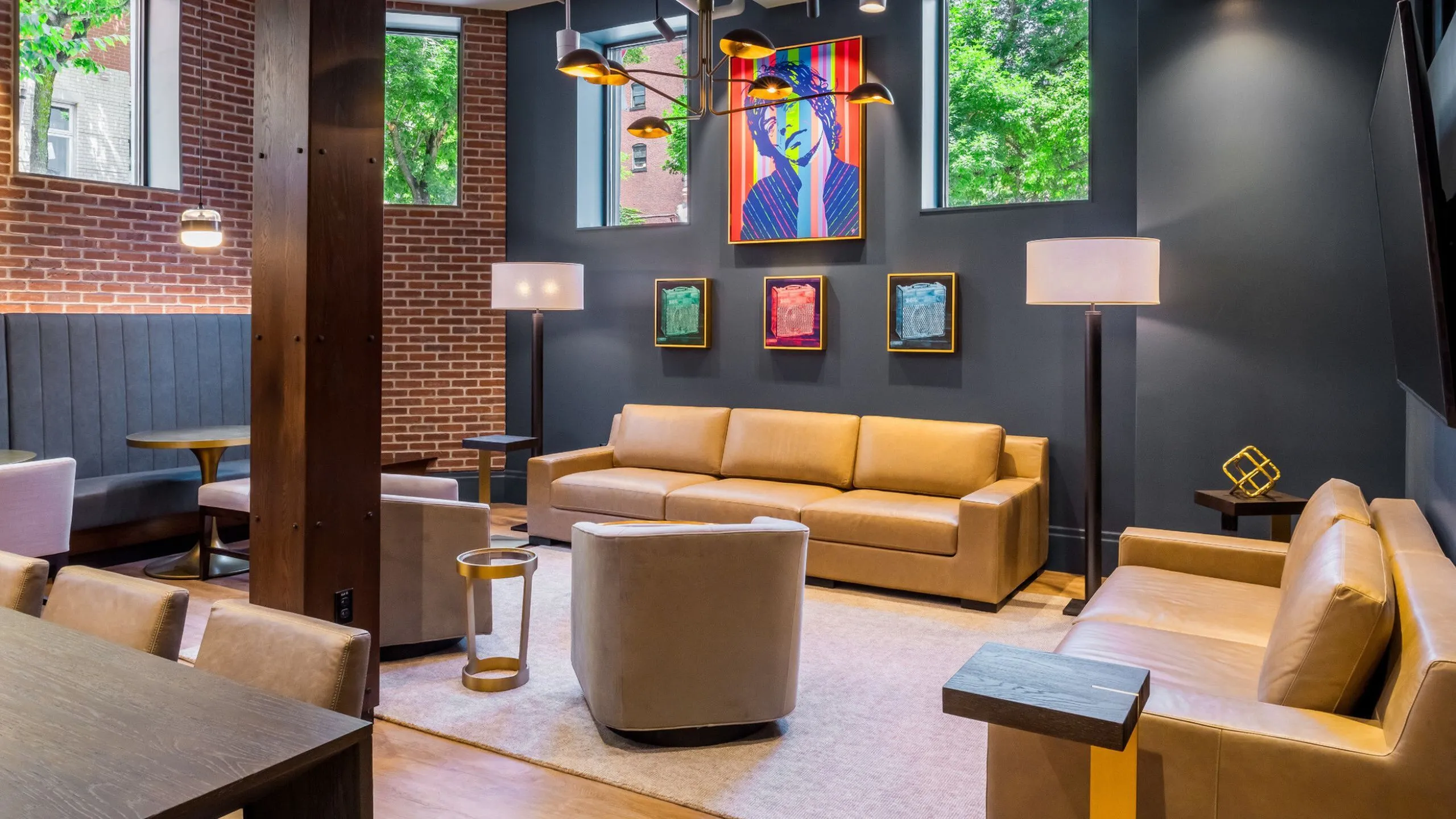Chic lounge area with modern art, cozy leather sofas, and vibrant natural lighting, ideal for social gatherings.