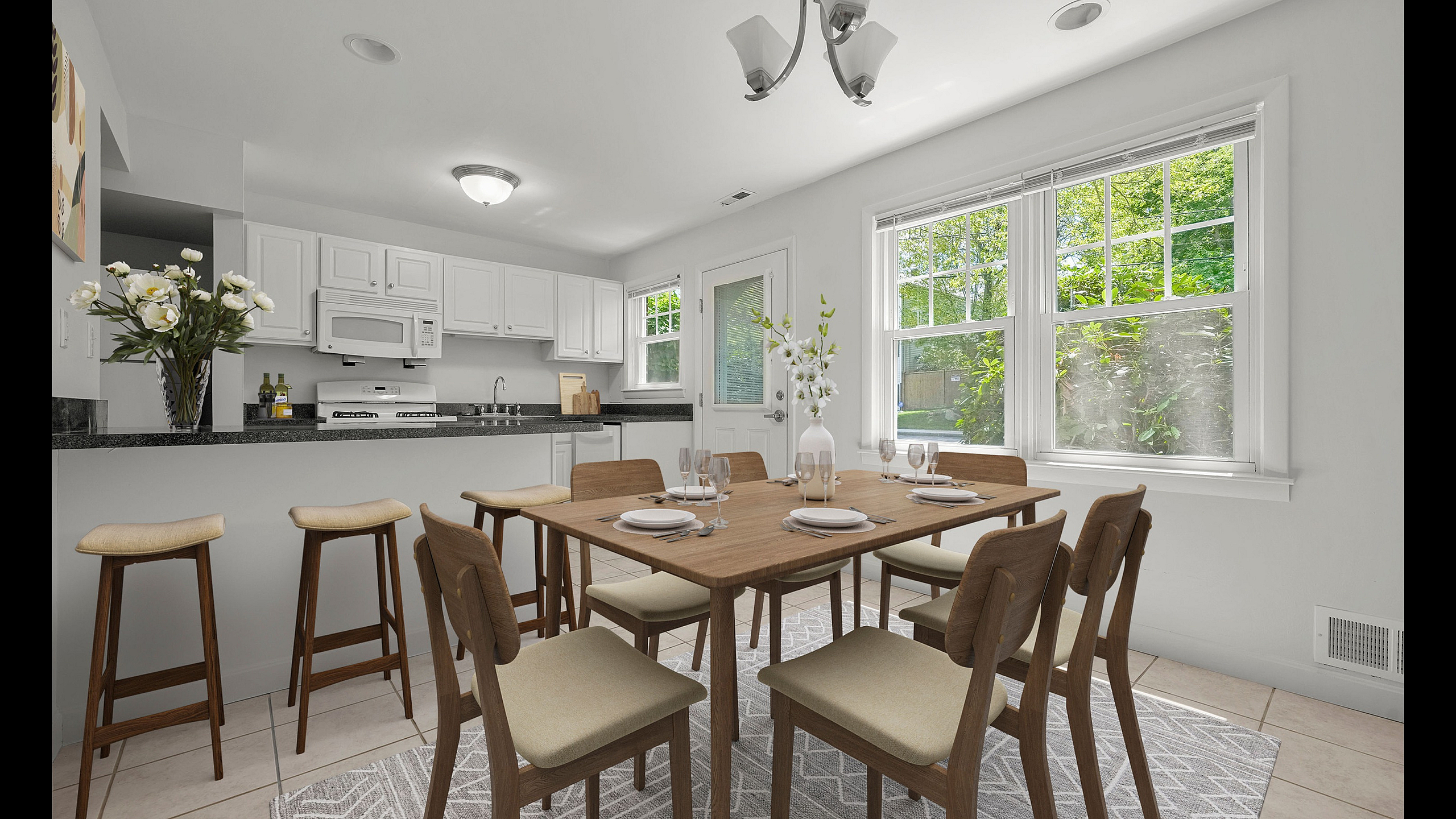 Bright and inviting kitchen and dining area featuring modern cabinetry, elegant lighting, and scenic garden views through large windows.