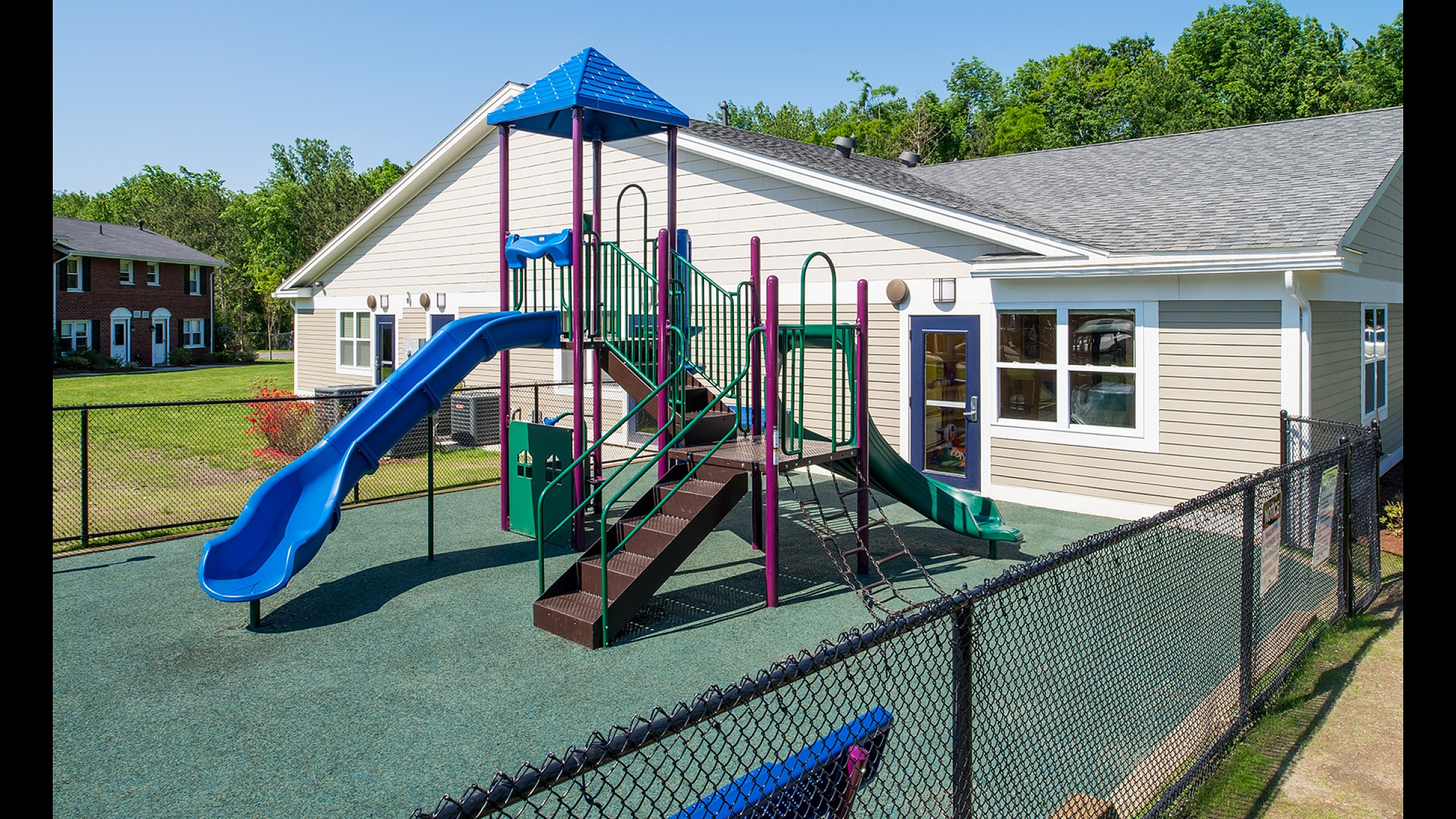 Charming residential playground featuring vibrant slides and climbing structures, ideal for family living.