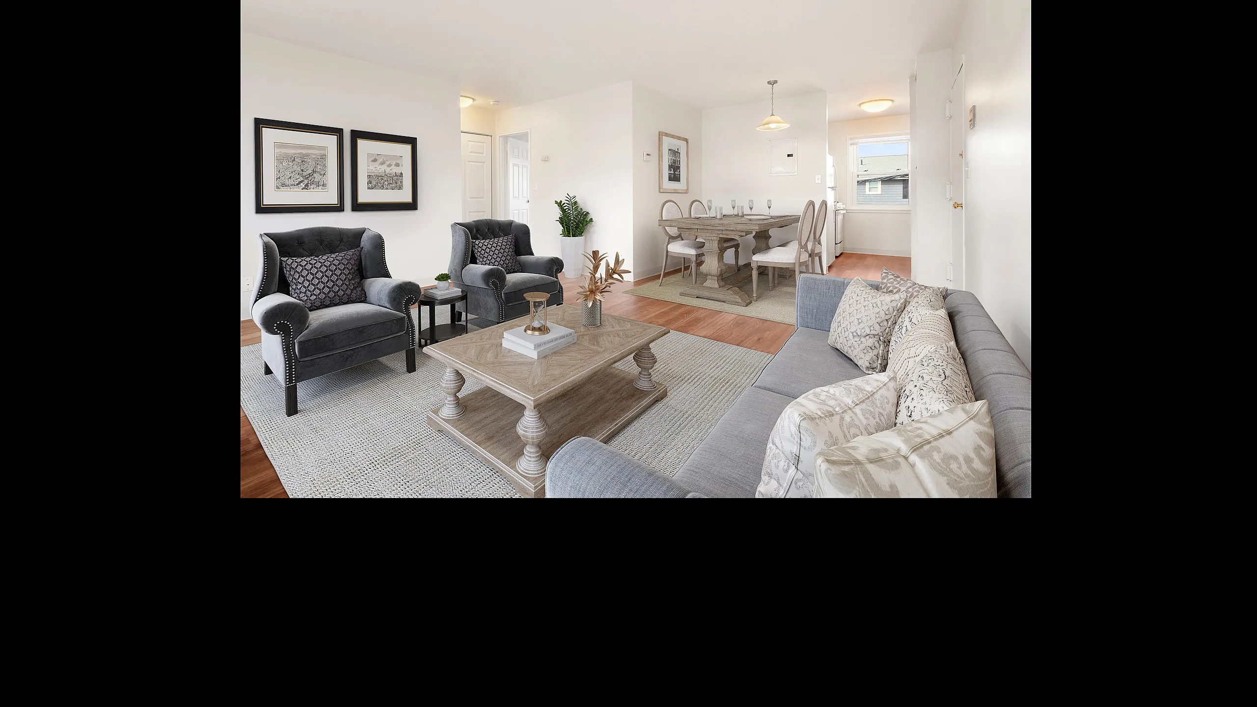 Inviting living space with elegant gray armchairs, plush sofa, and chic dining area, perfect for entertaining in a beautifully lit setting.